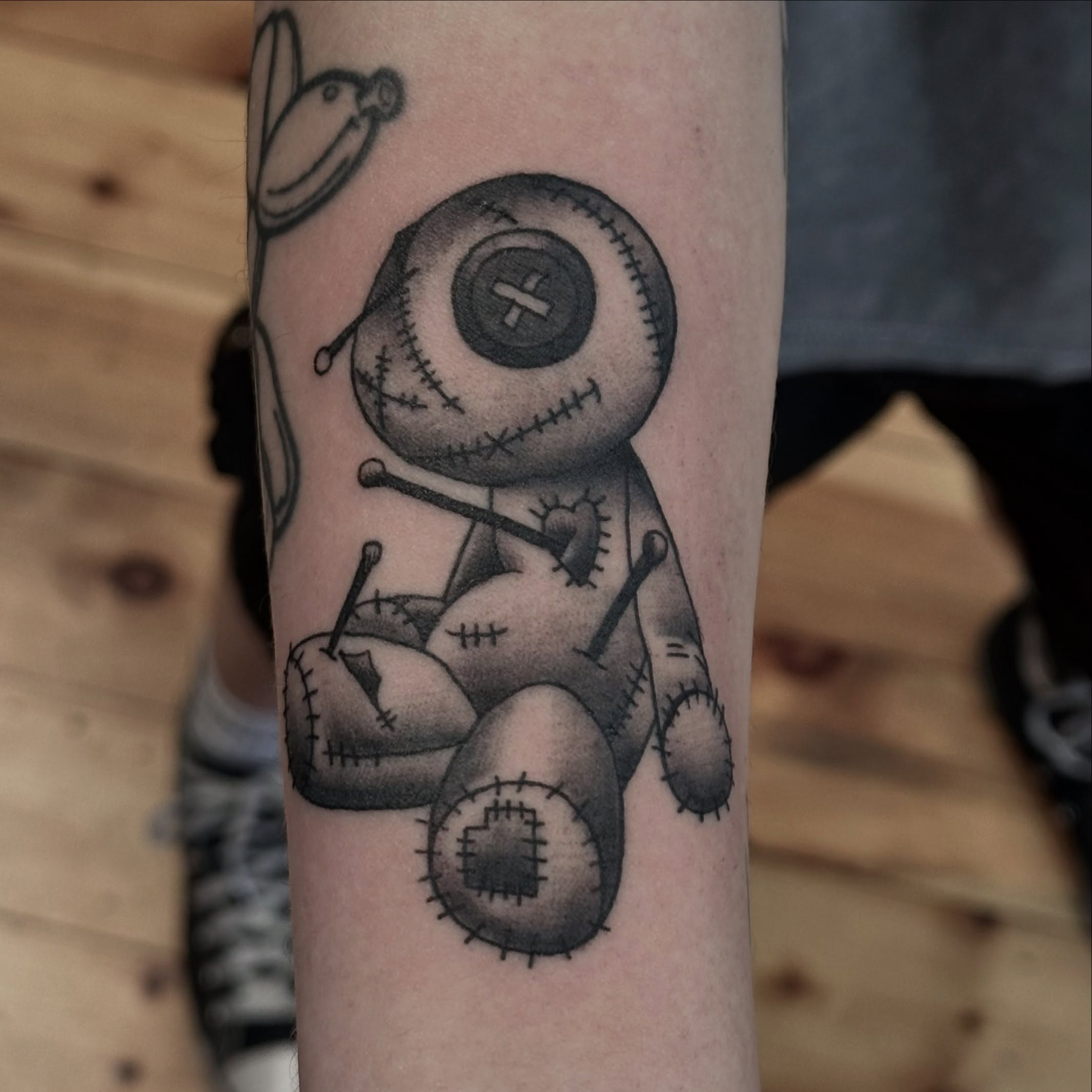 Voodoo doll black and grey tattoo on the forearm by Dylan Curry