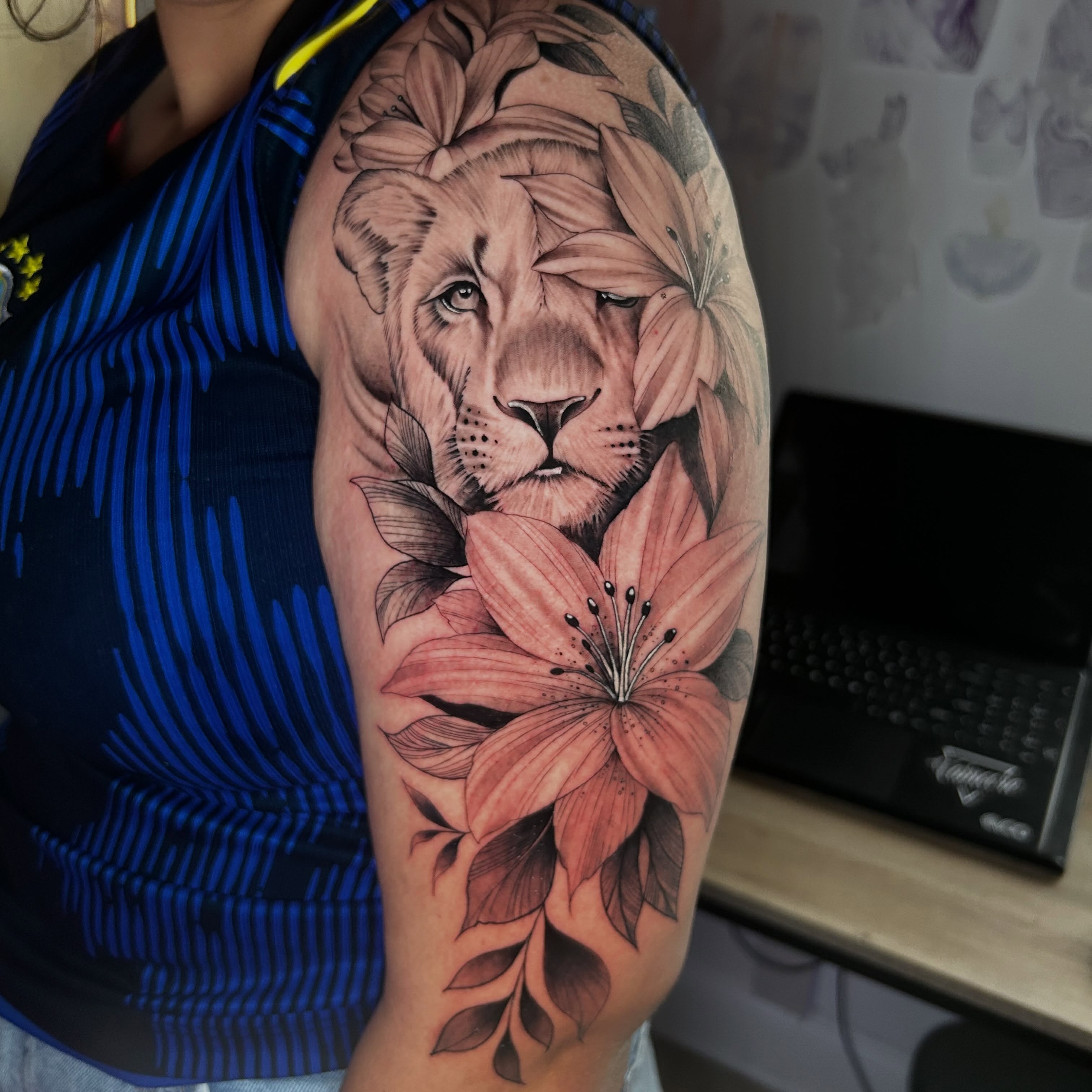 Lion and lilies realism tattoo on the upper arm by Denis Morello de Castro, South River, New Jersey