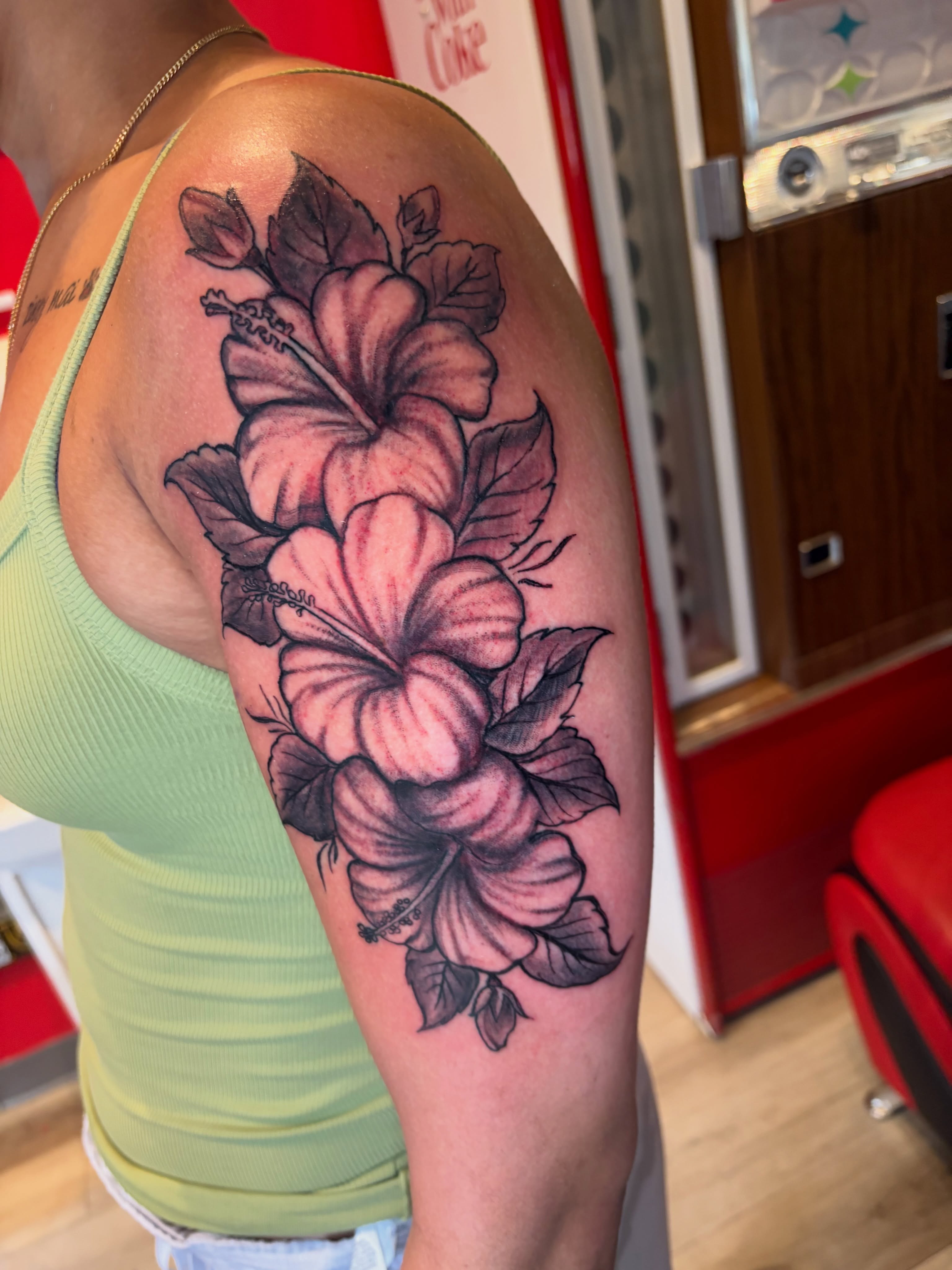 Hibiscus flowers realism tattoo on the upper arm by Calen Copeland