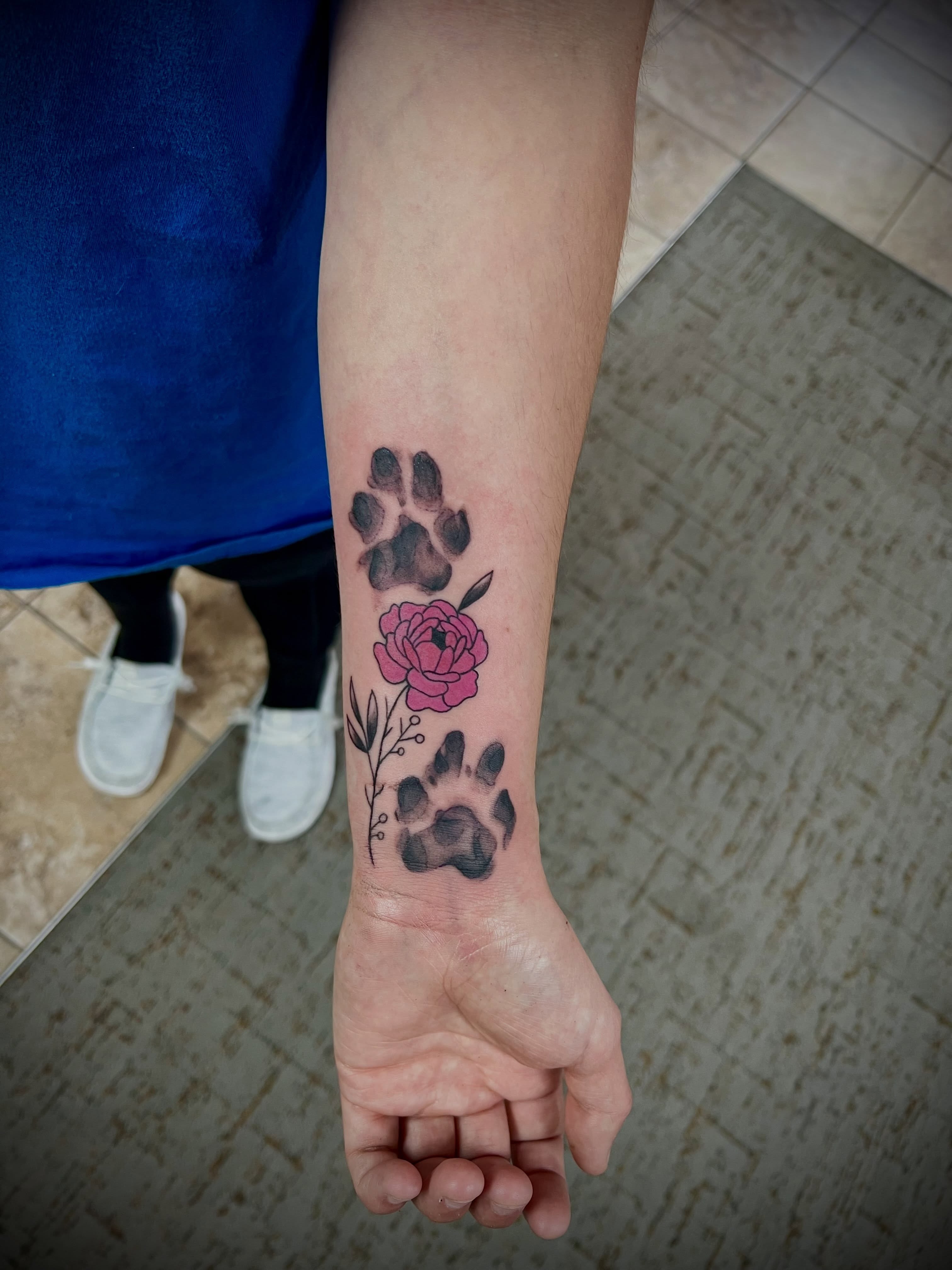 Paw prints and flower dotwork tattoo on the forearm by Austin Hill