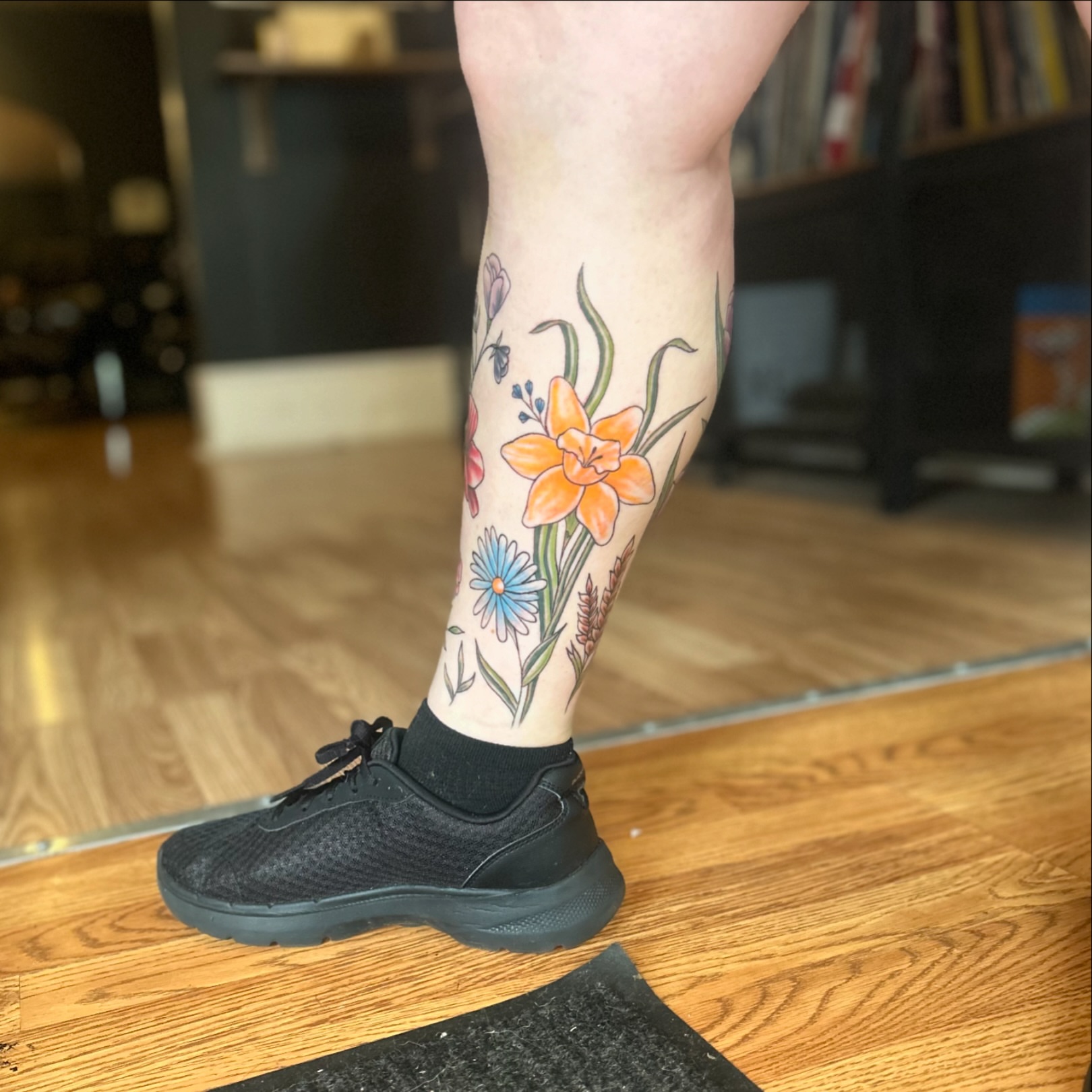 Floral bouquet new school tattoo on the calf by Tori Magill
