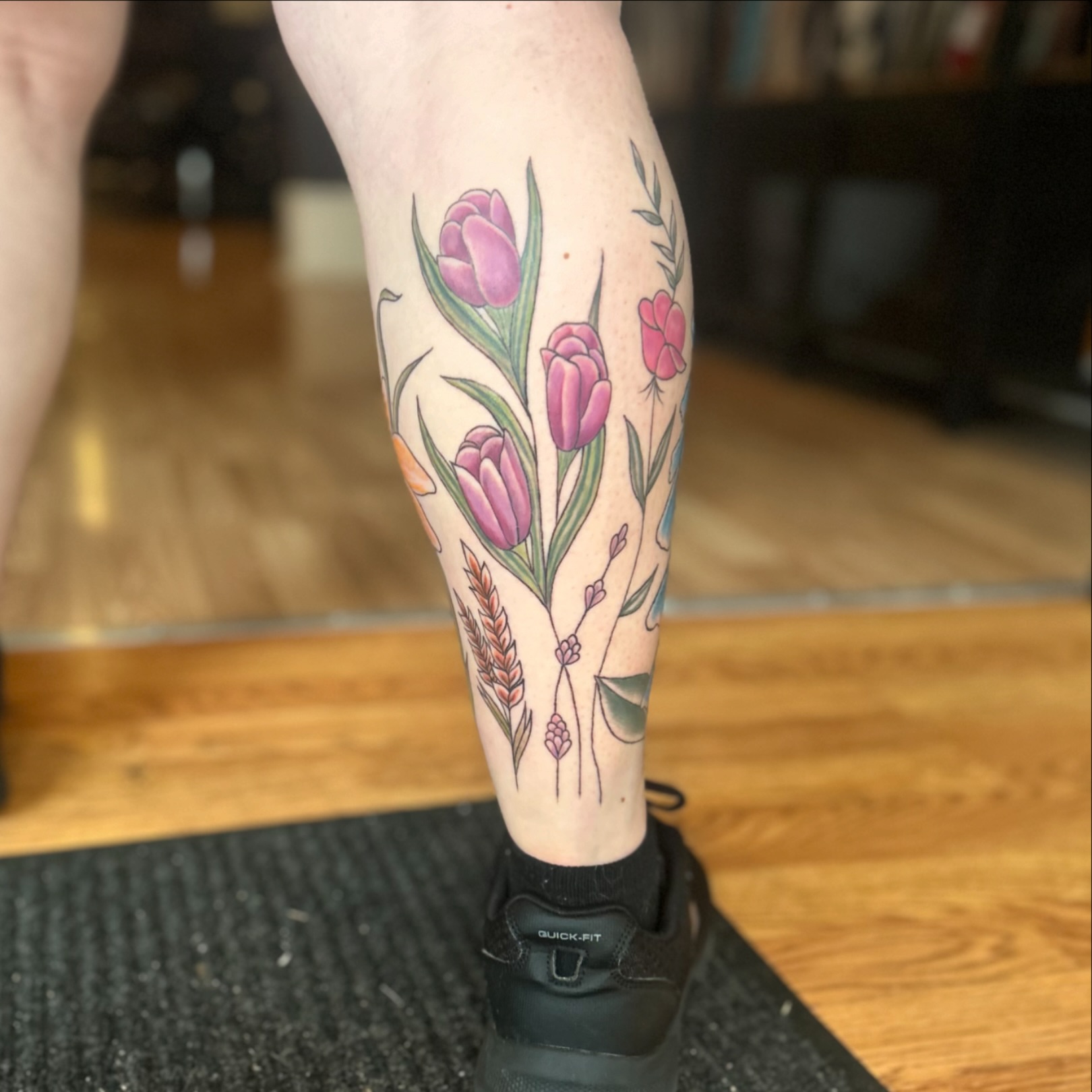 Tulips and wheat new school tattoo on the calf by Tori Magill