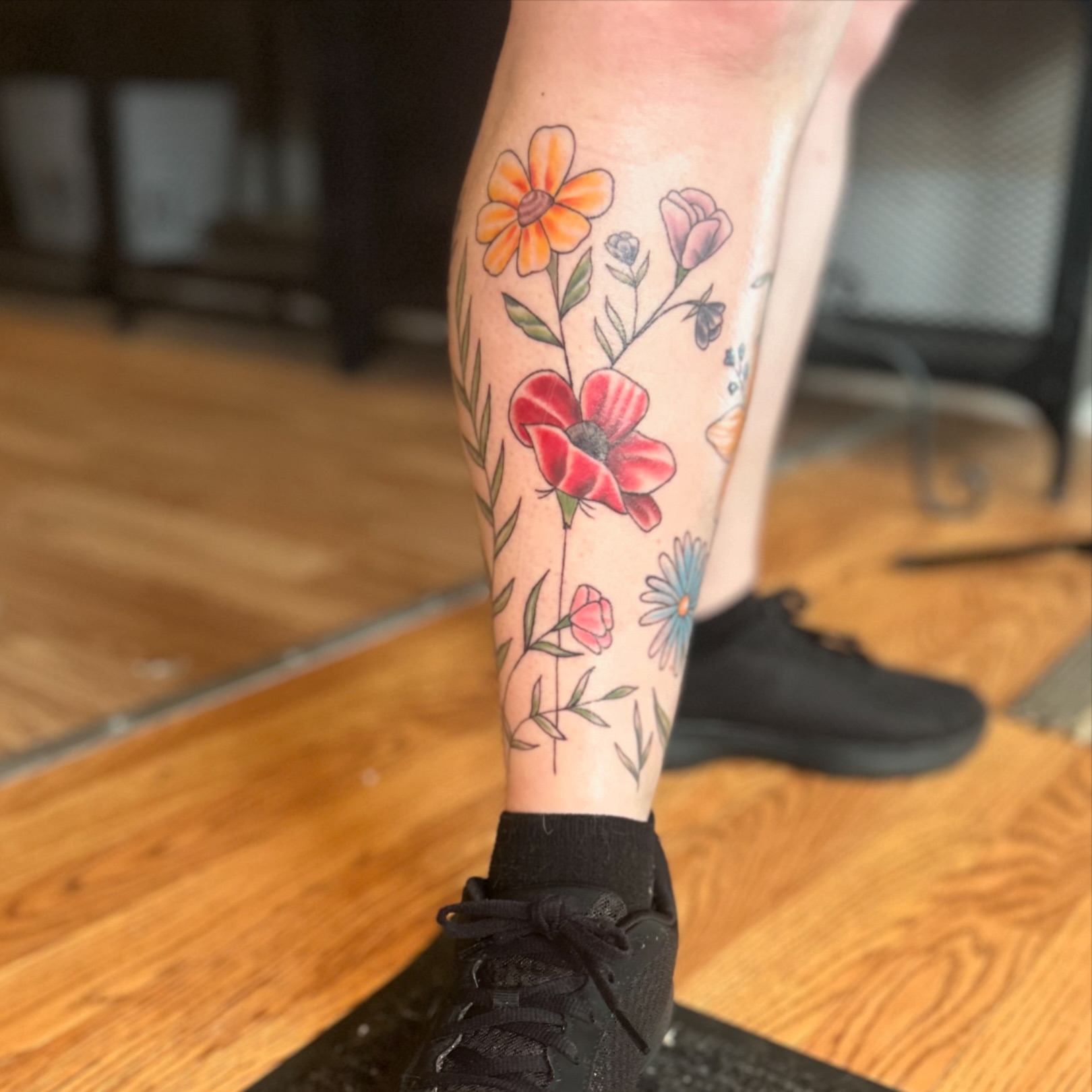 Floral arrangement new school tattoo on the calf by Tori Magill