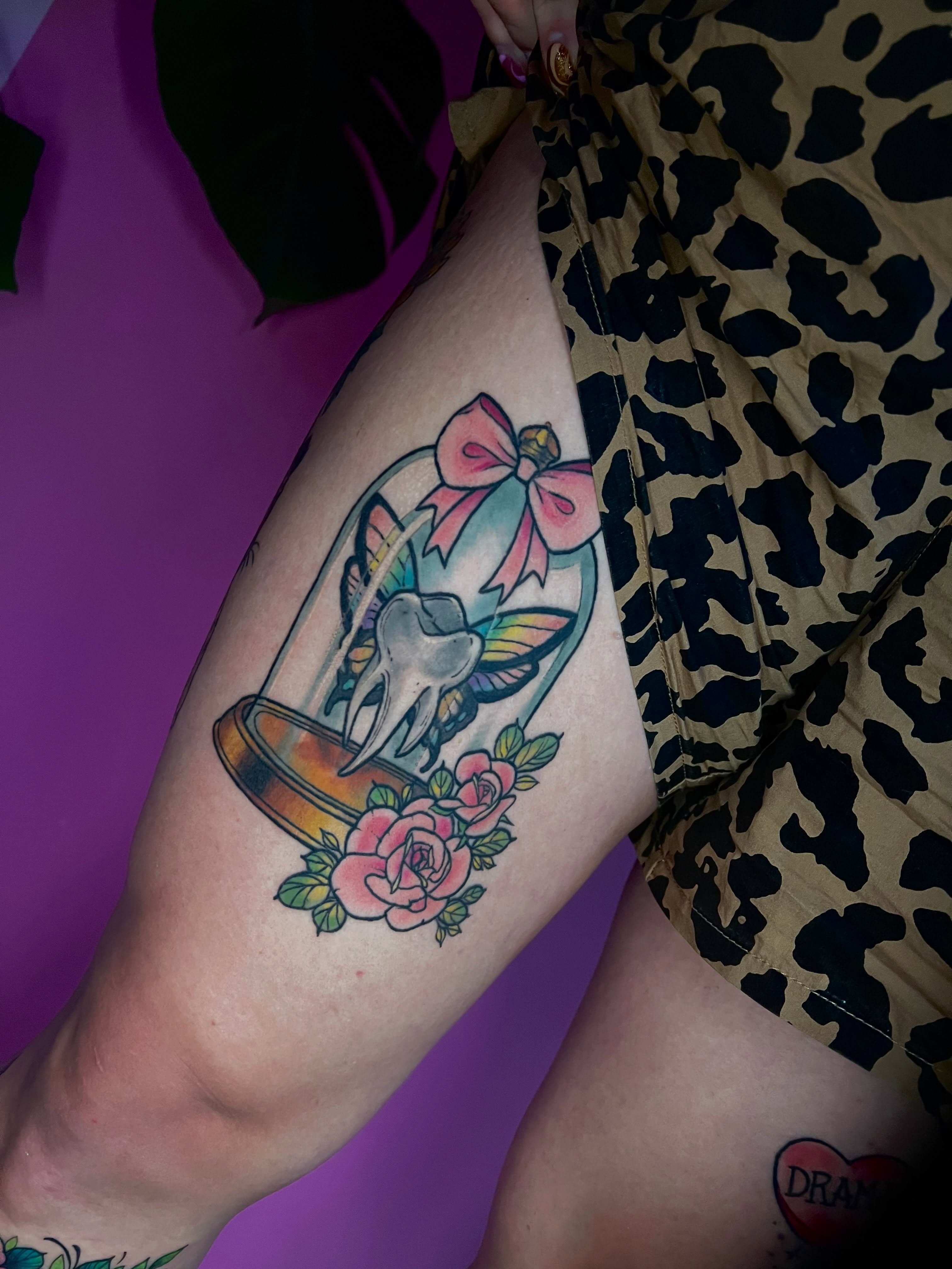 Glass dome with skull and flowers American traditional tattoo on the thigh by jessica valentine