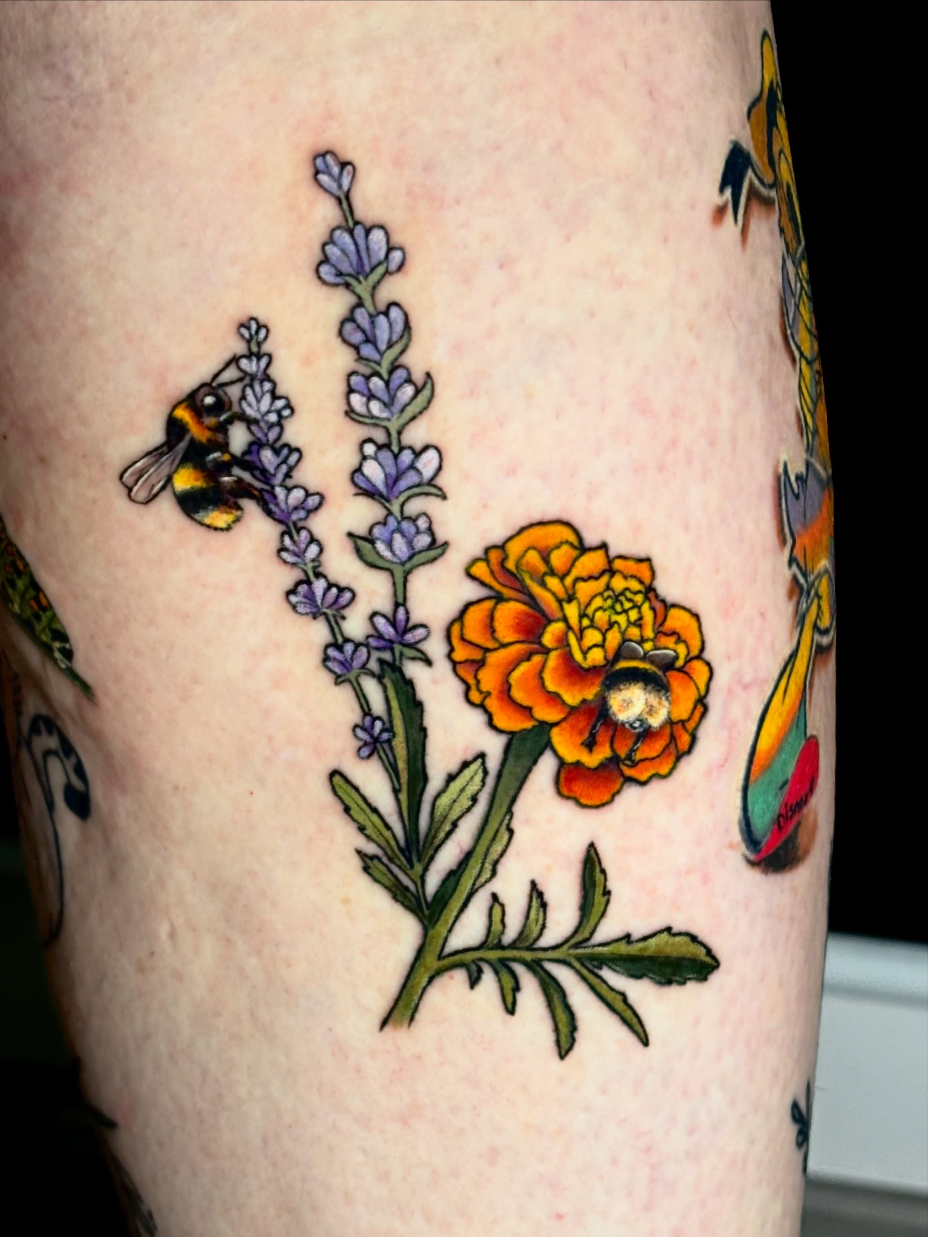 Bee and marigold American traditional tattoo on the forearm by Sarah Sacco