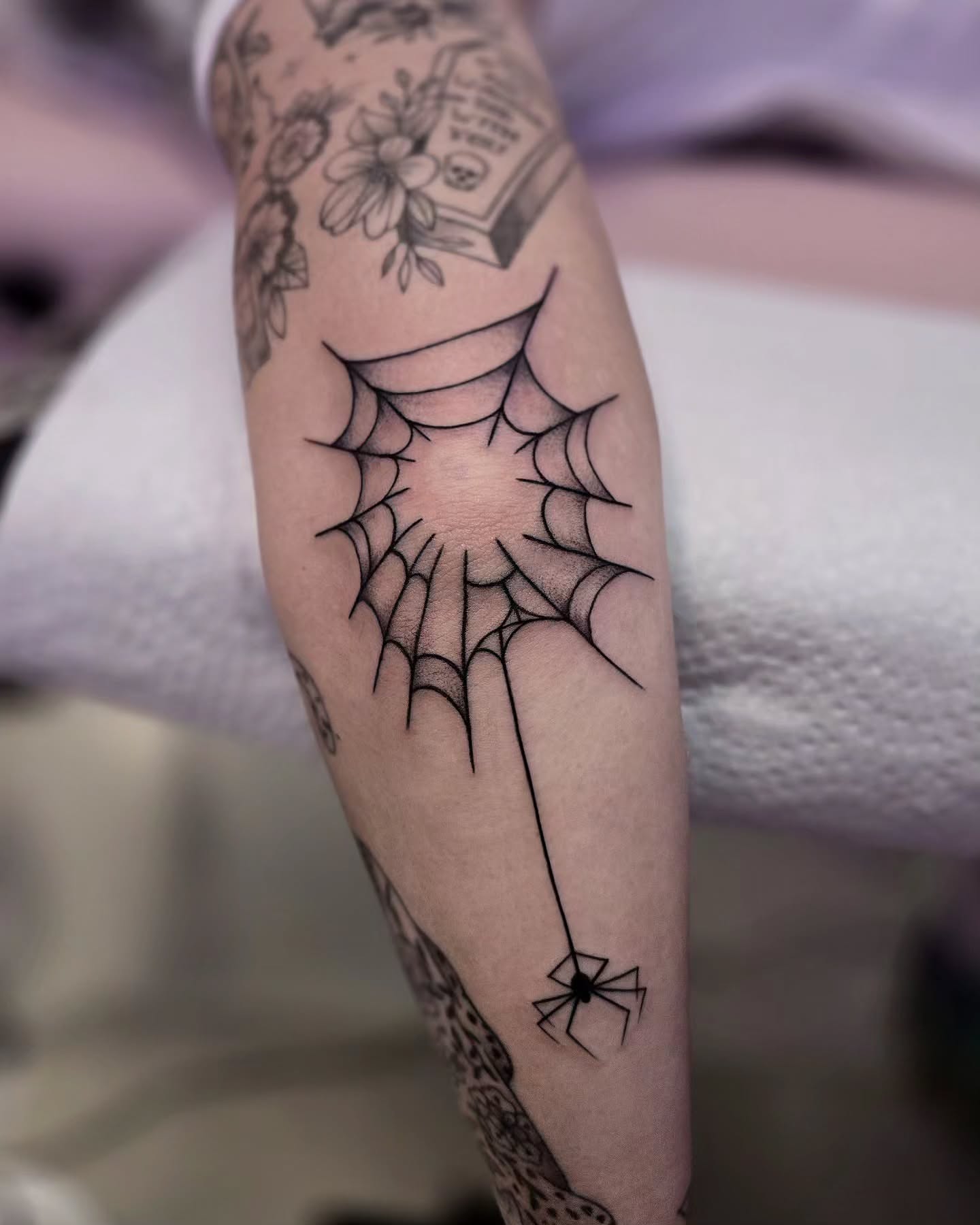 Spider web black and grey tattoo on the forearm by Kirstie Lew Tattoo