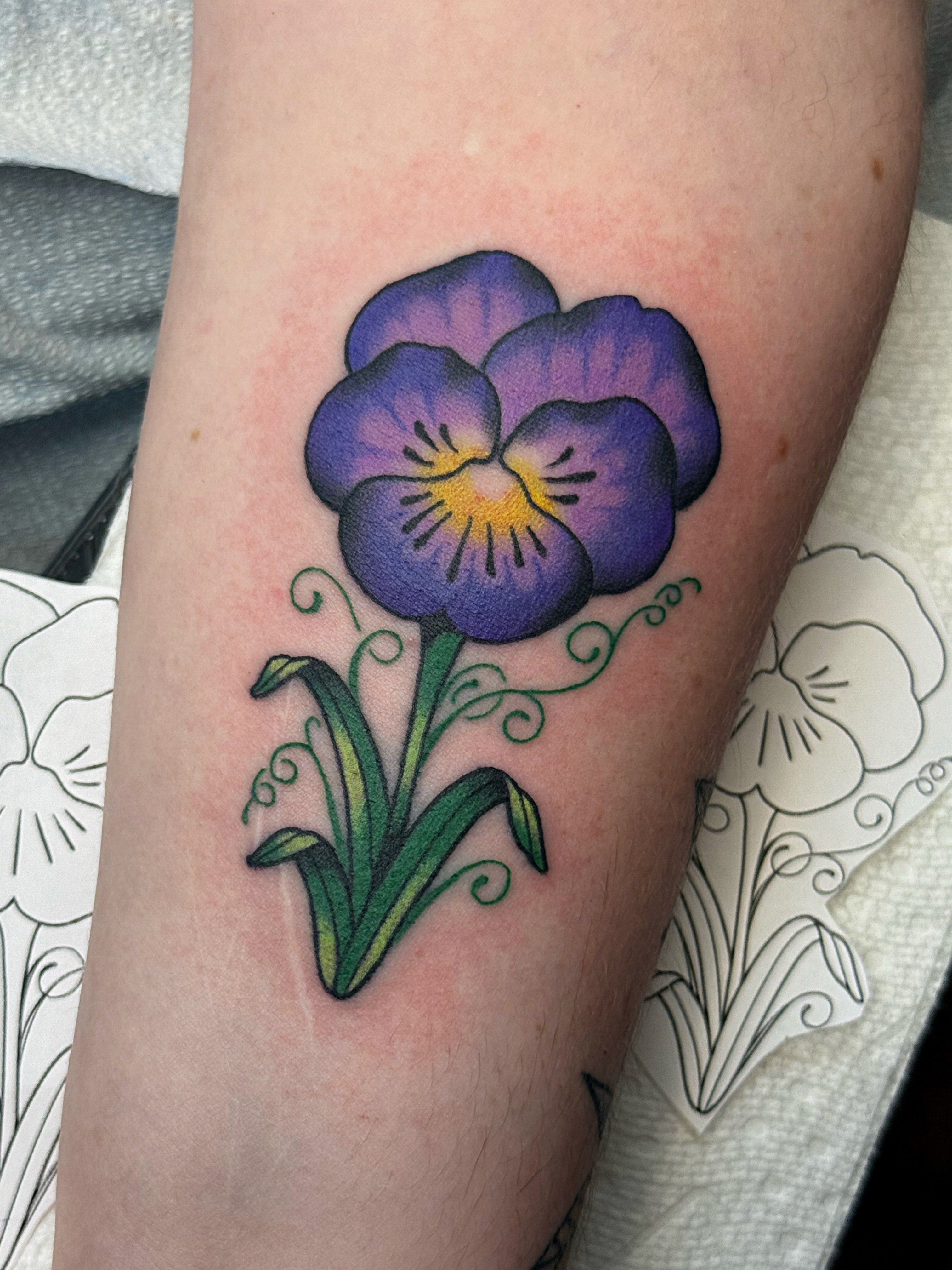 Purple pansy realism tattoo on the forearm by vic