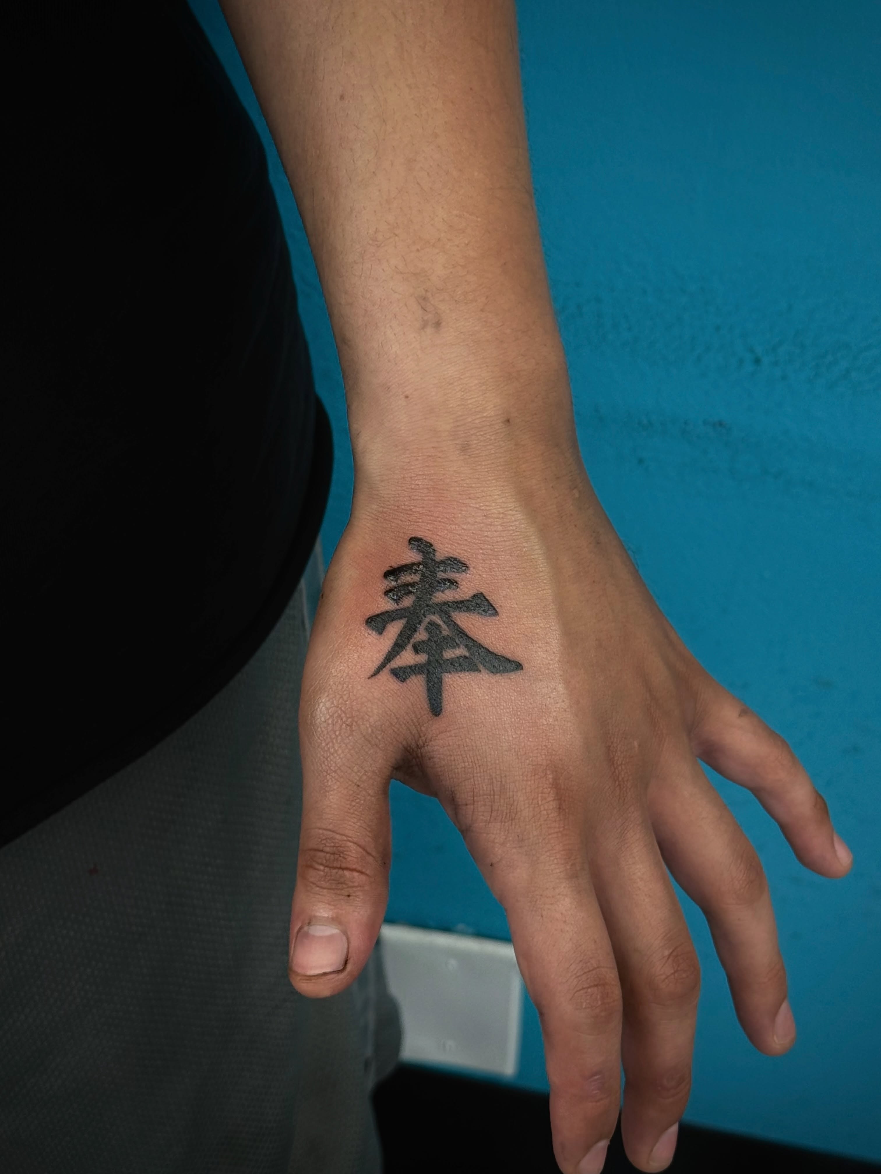 Kanji character black and grey tattoo on the hand by ⠀Greave