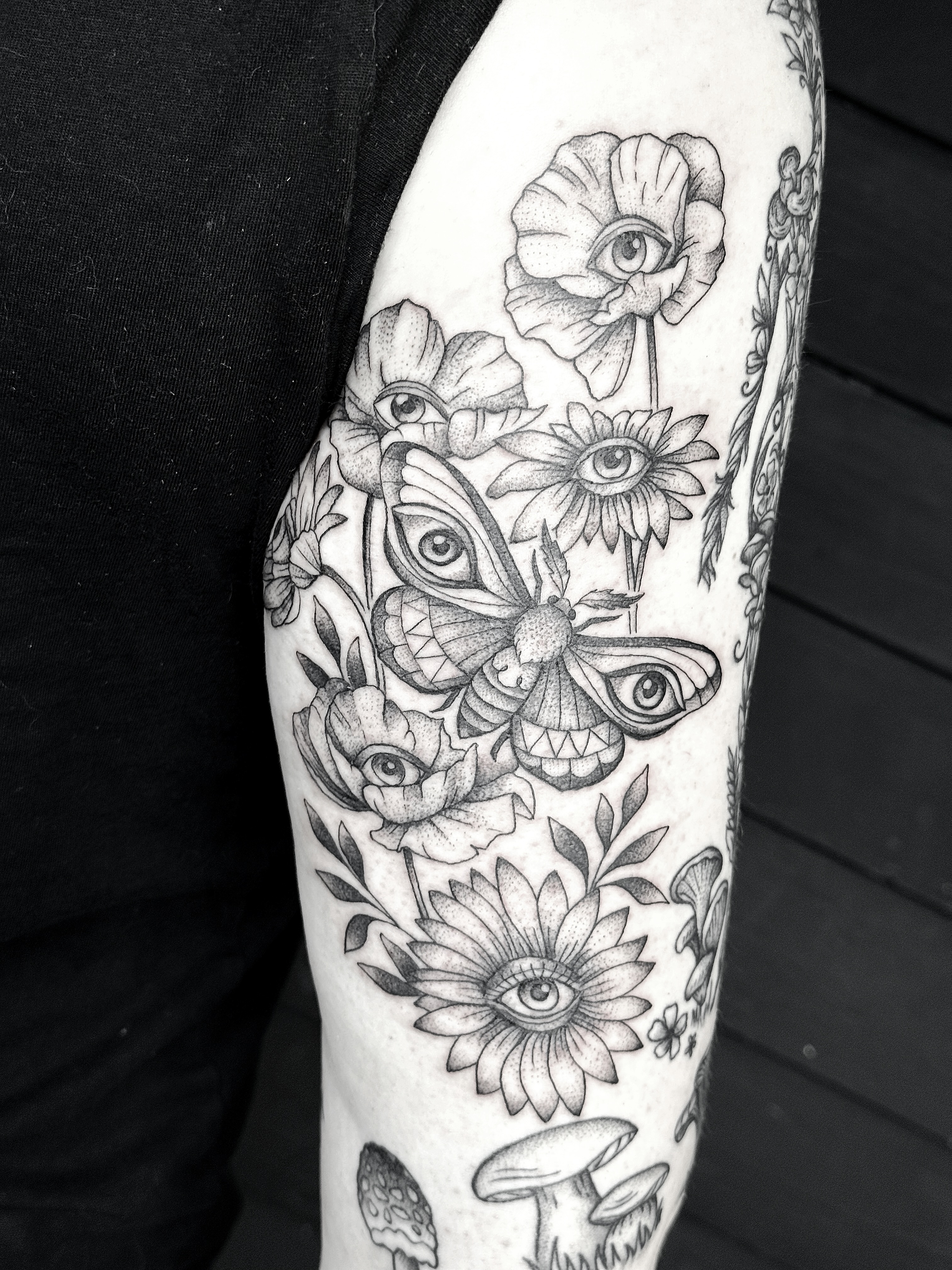 Moths, flowers, eyes dotwork tattoo on the forearm by Breezy Tucker