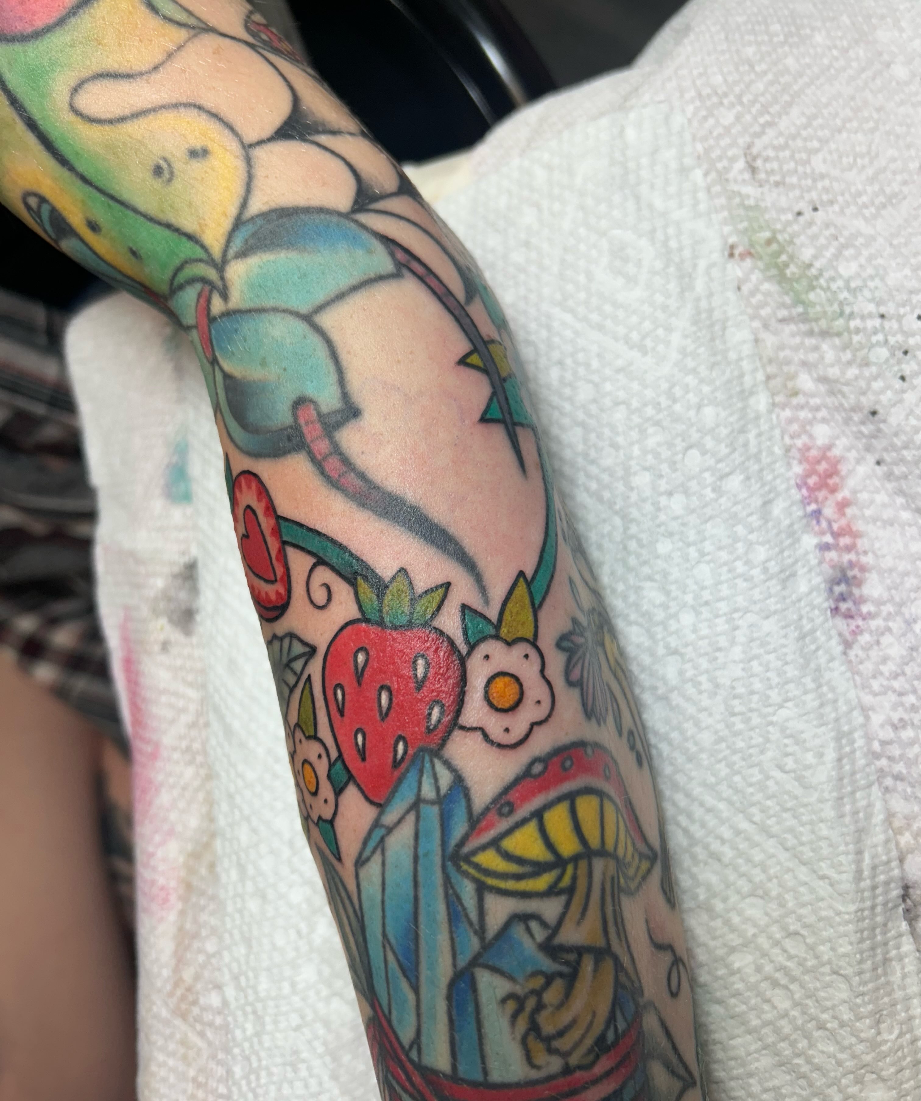 Strawberry and mushroom American traditional tattoo on the forearm by Kelsey Lyons
