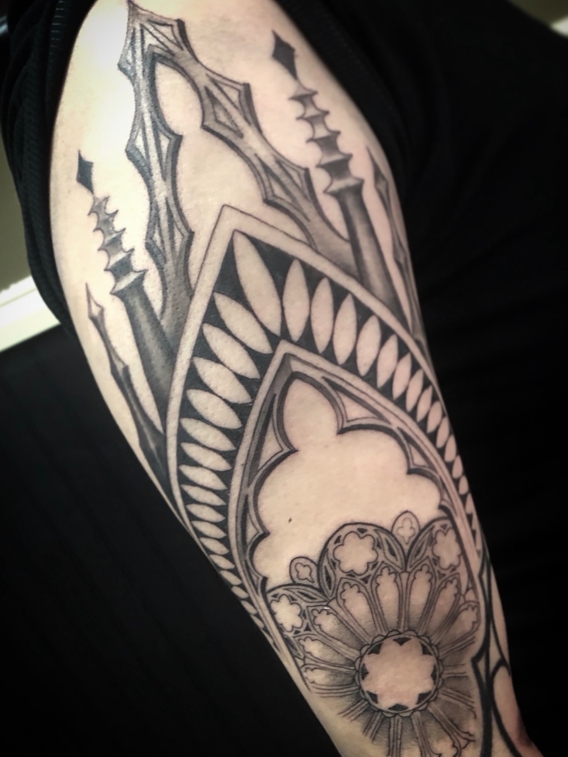 Gothic arches and floral geometric tattoo on the forearm by Cassandra Colleen