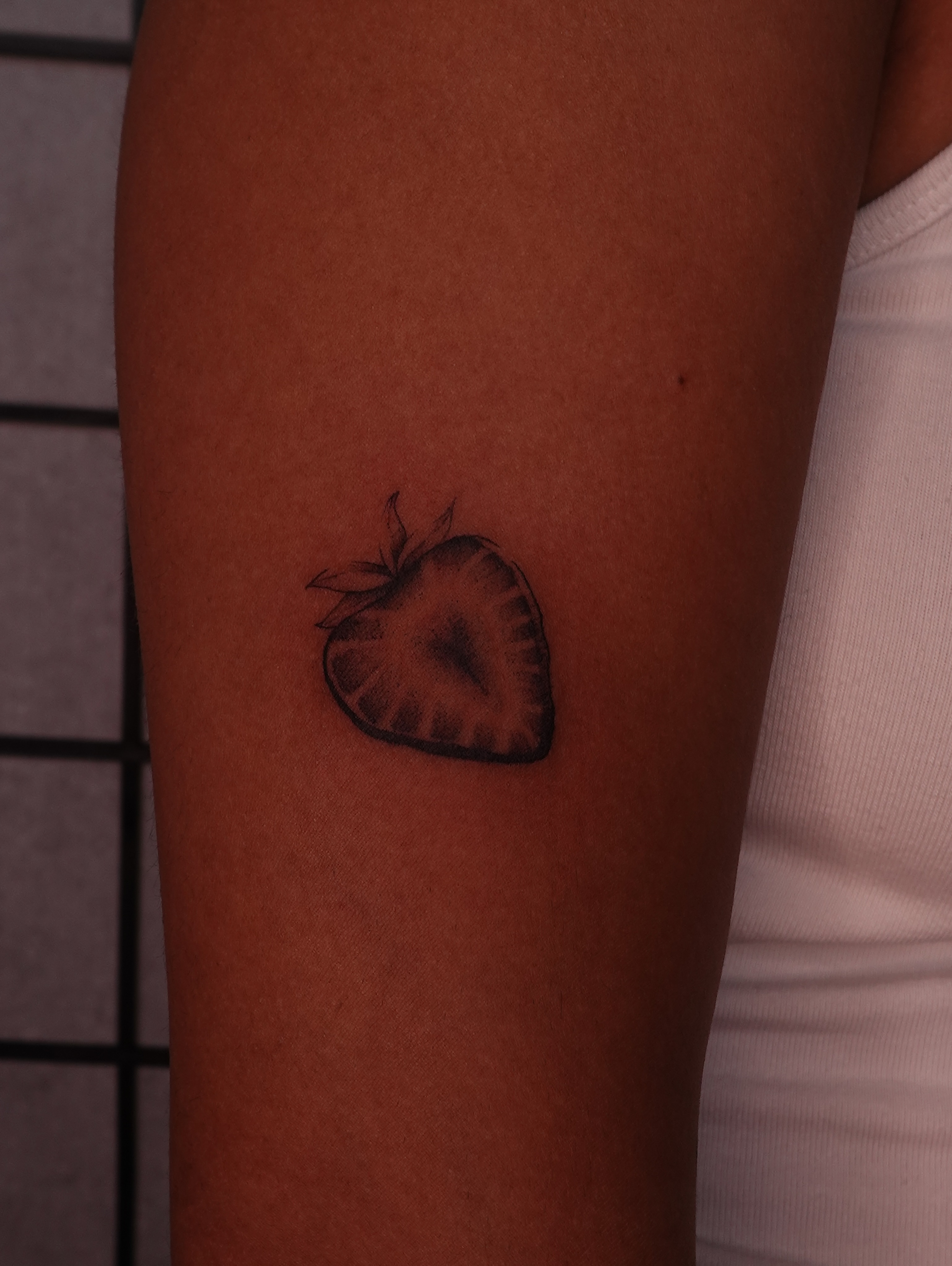 Strawberry black and grey tattoo on the forearm by jun