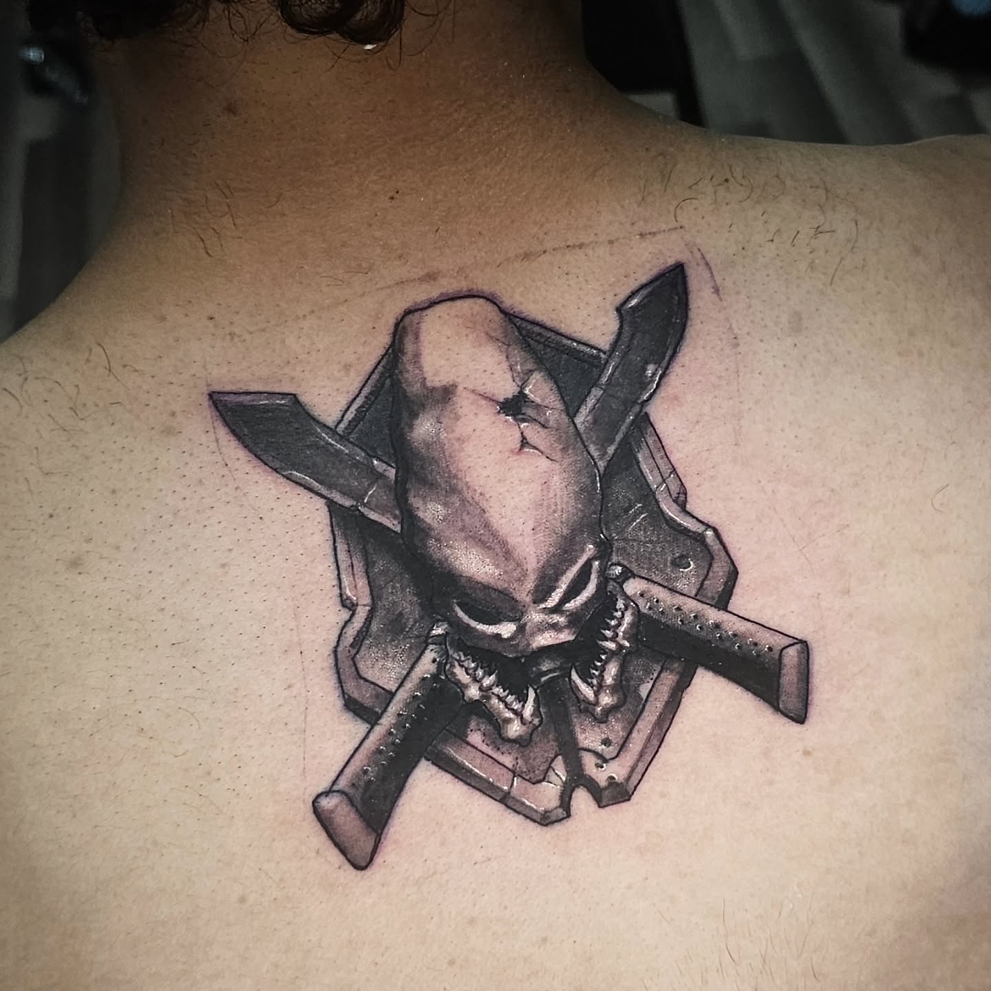 Skull and crossed knives geometric tattoo on the back by Cody Gower Tattoo Artist