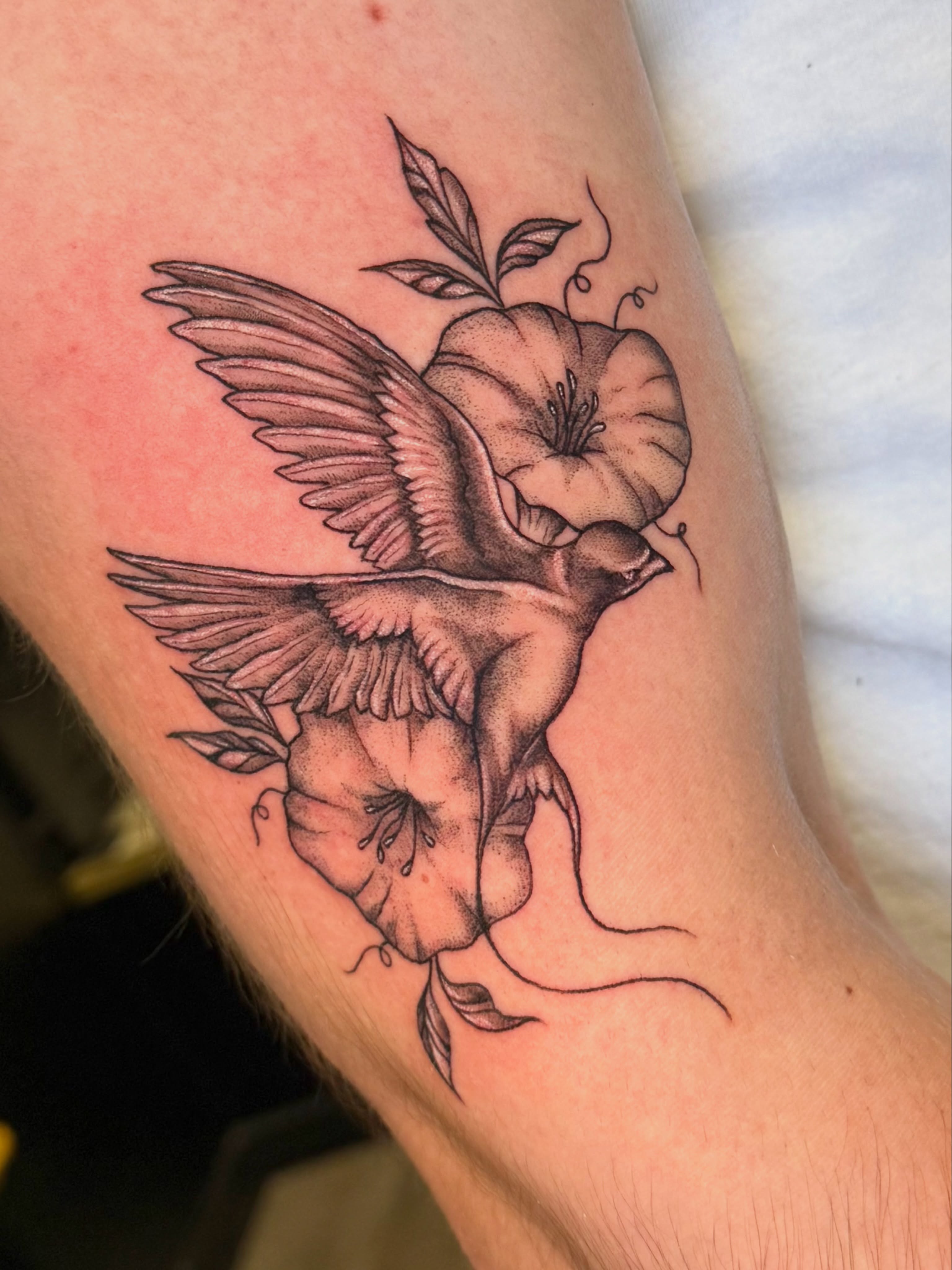 Bird and flower realism tattoo on the forearm by Tyla Pistak, Seattle, Washington