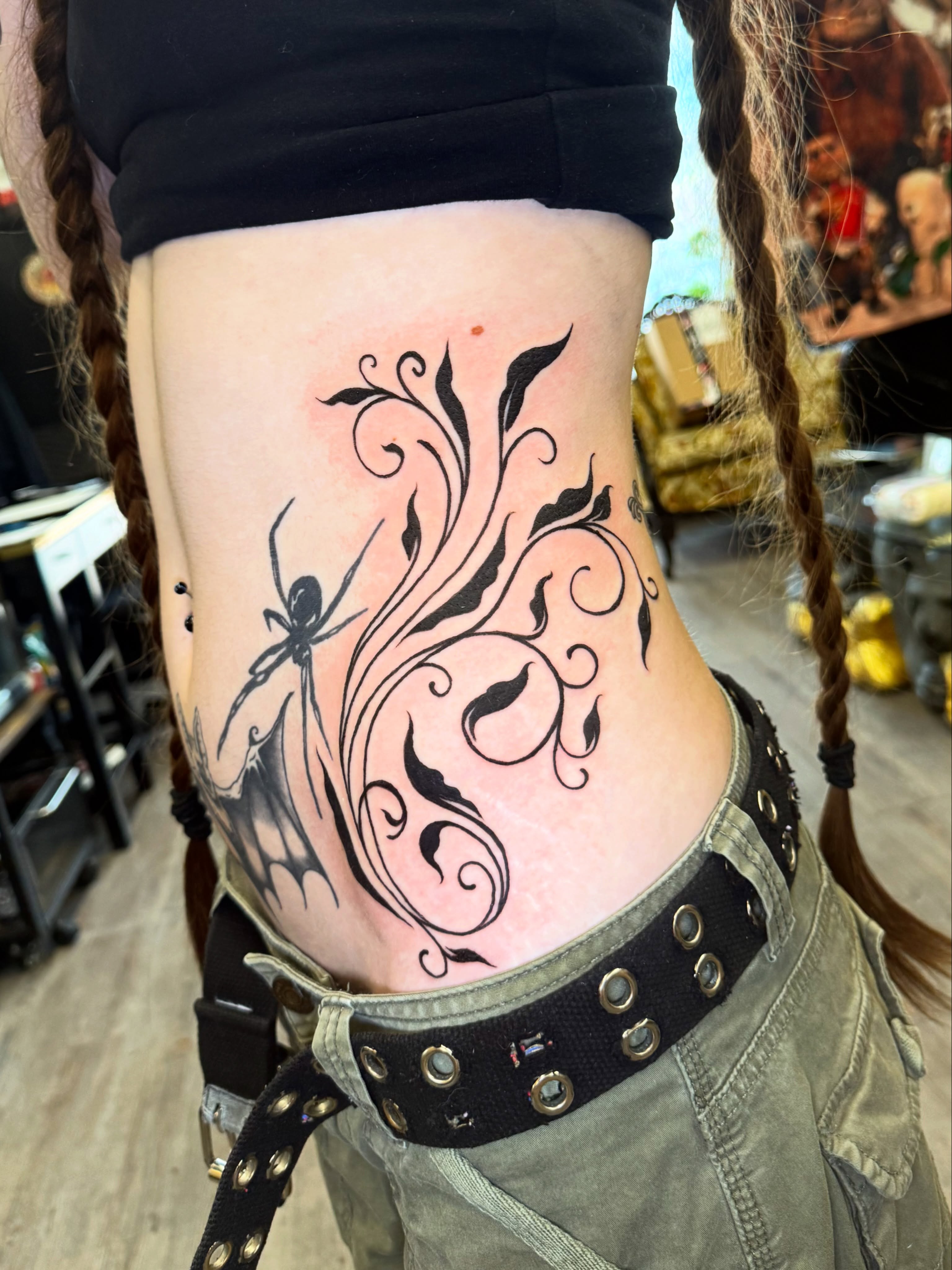 Spider and swirls black and grey tattoo on the ribs by Tyla Pistak, Seattle, Washington