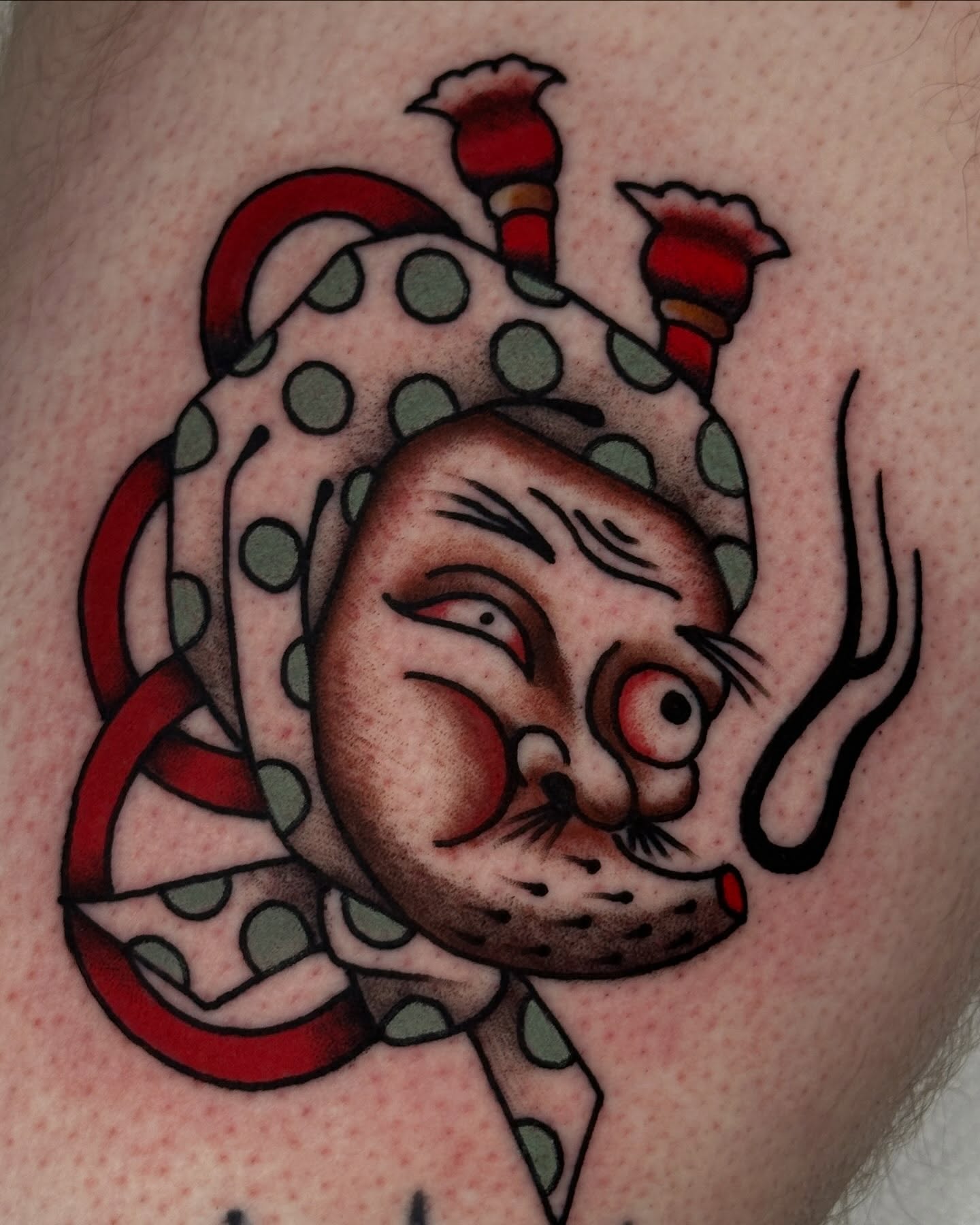 Clown head American traditional tattoo on the upper arm by Kyle Logan Frary