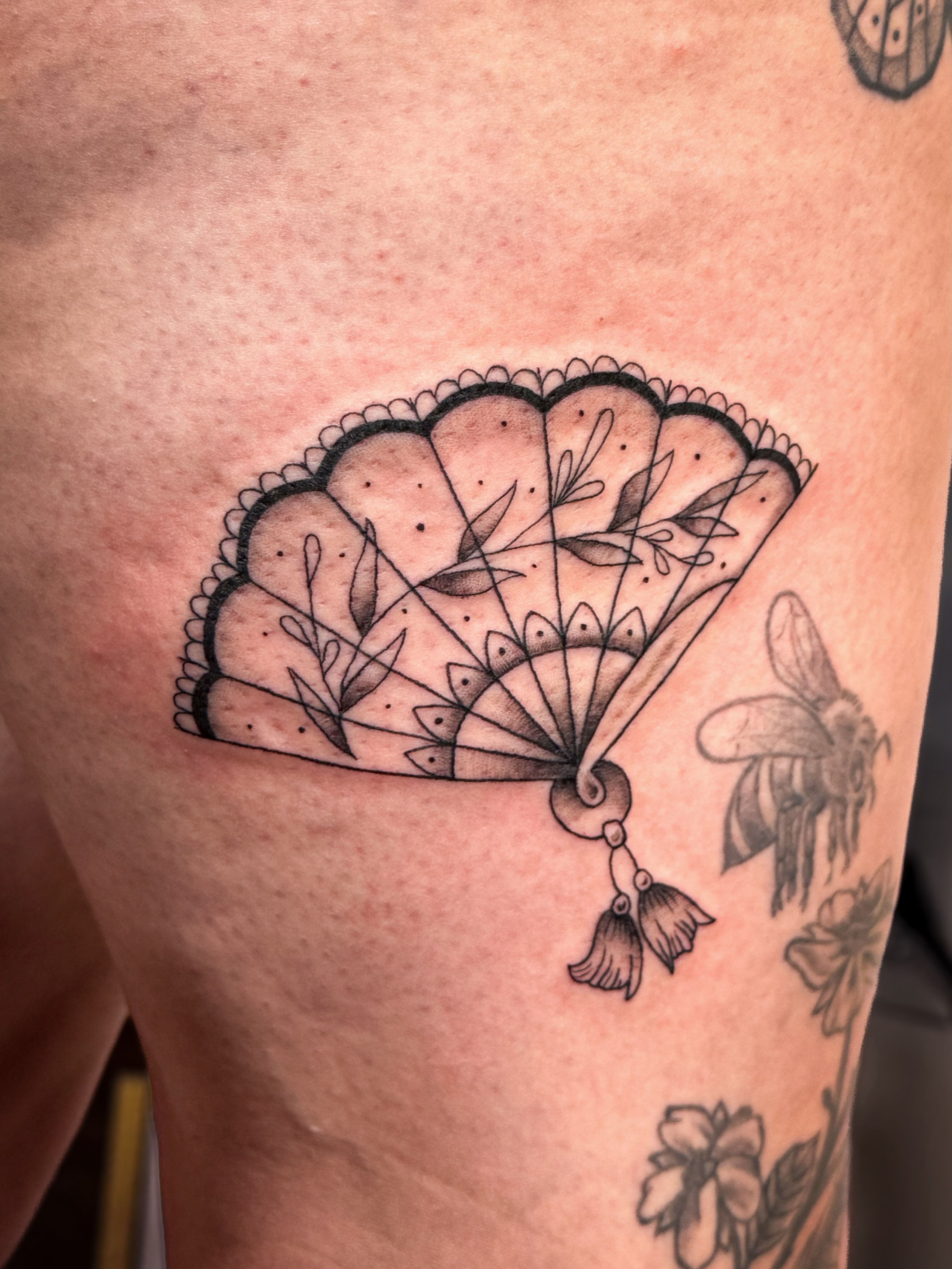 Fan black and grey tattoo on the thigh by Ash✨
