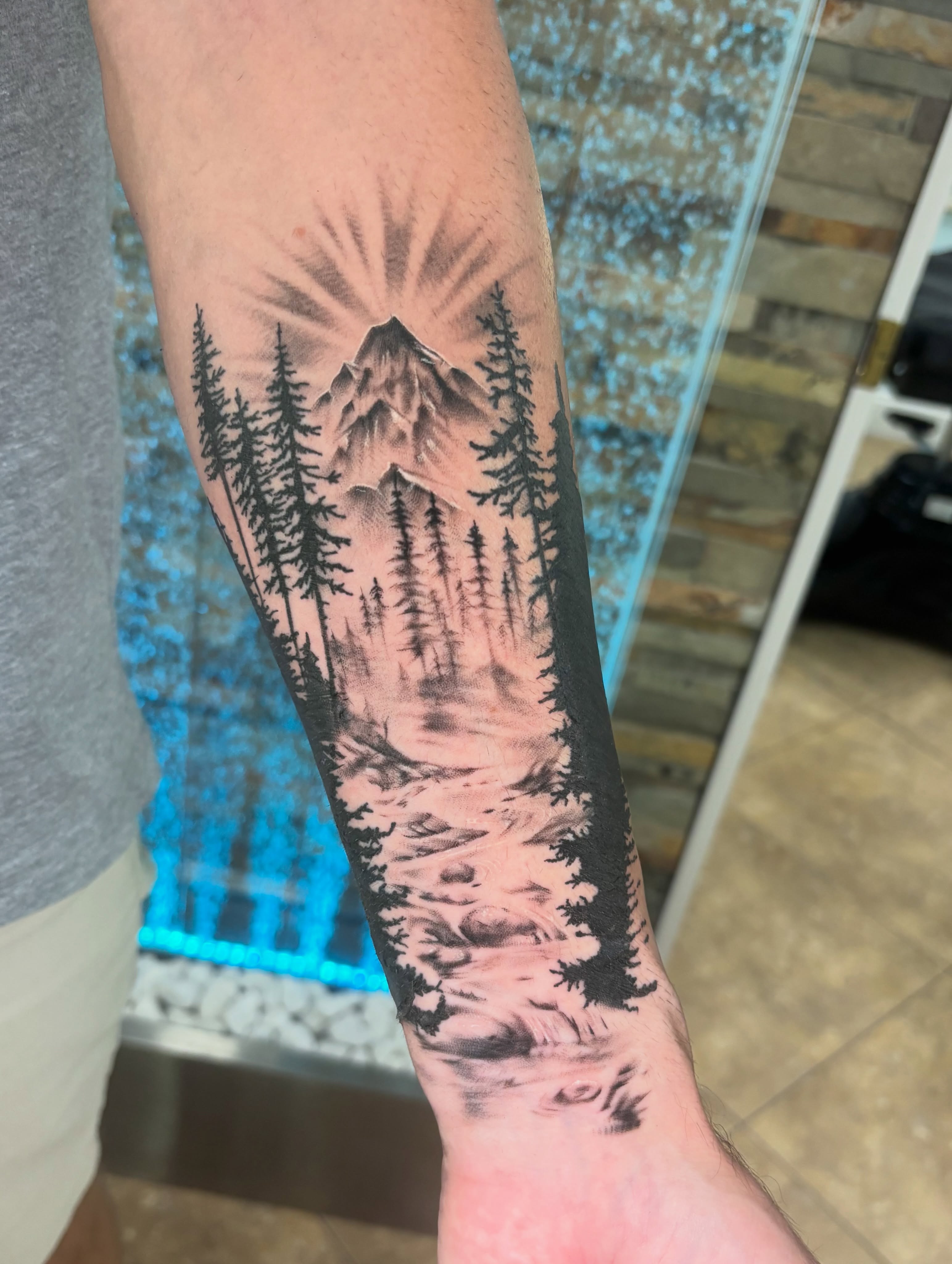 Mountain landscape realism tattoo on the forearm by Stephanie Rowe