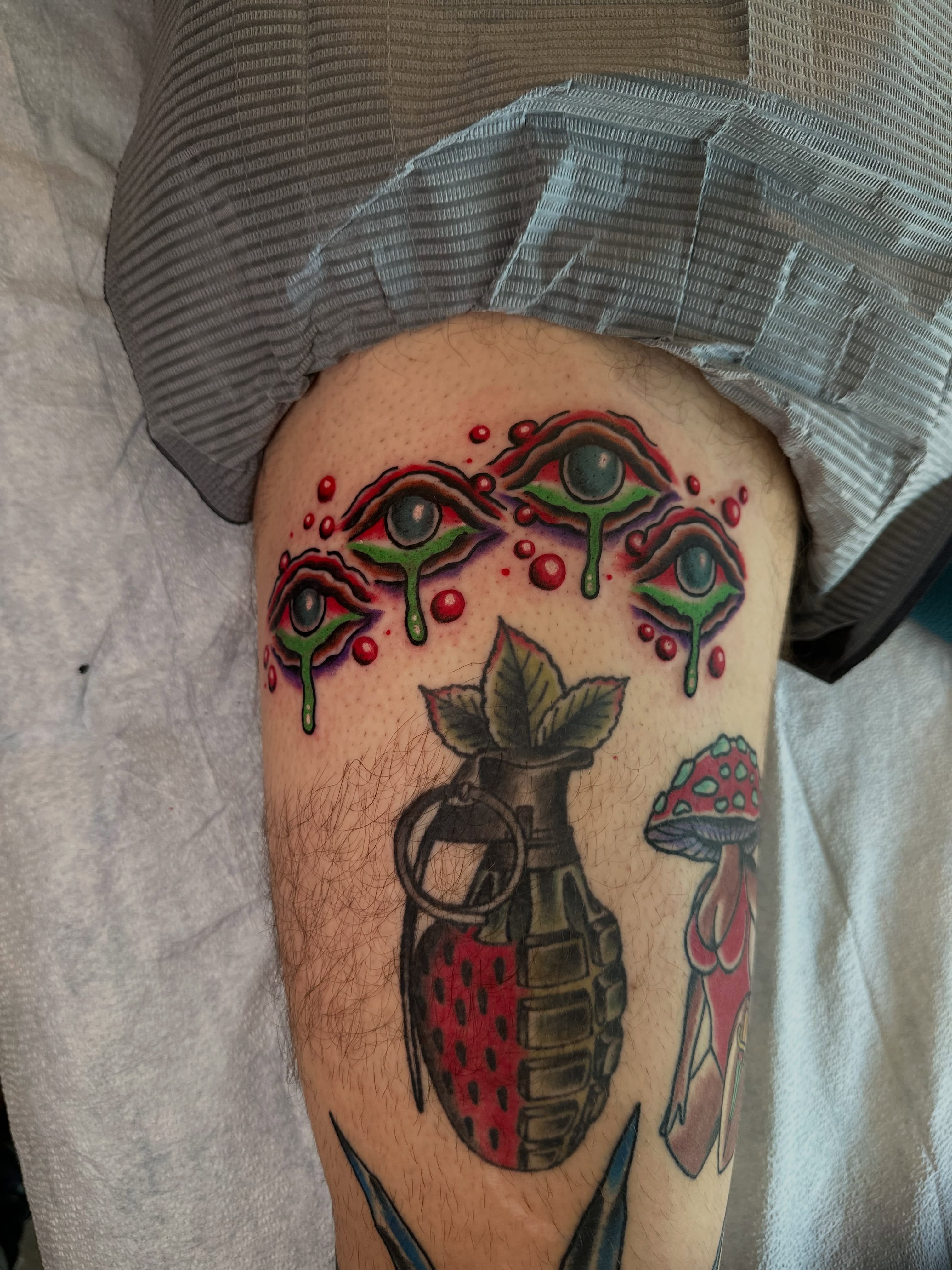 Eyes and grenade neo-traditional tattoo on the thigh by Whitney Creep Tattoos
