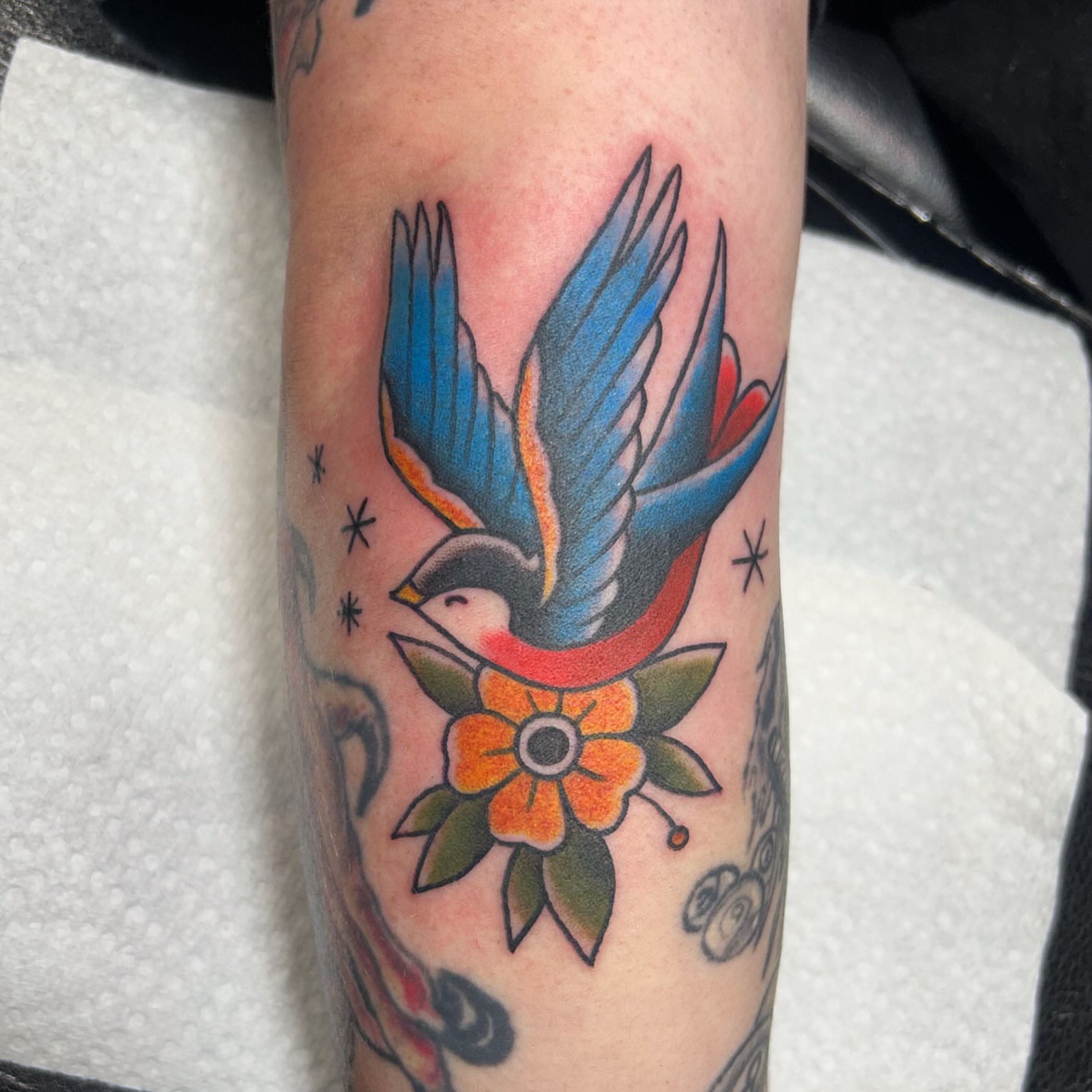 Bird and flower American traditional tattoo on the forearm by Danielle Dubois