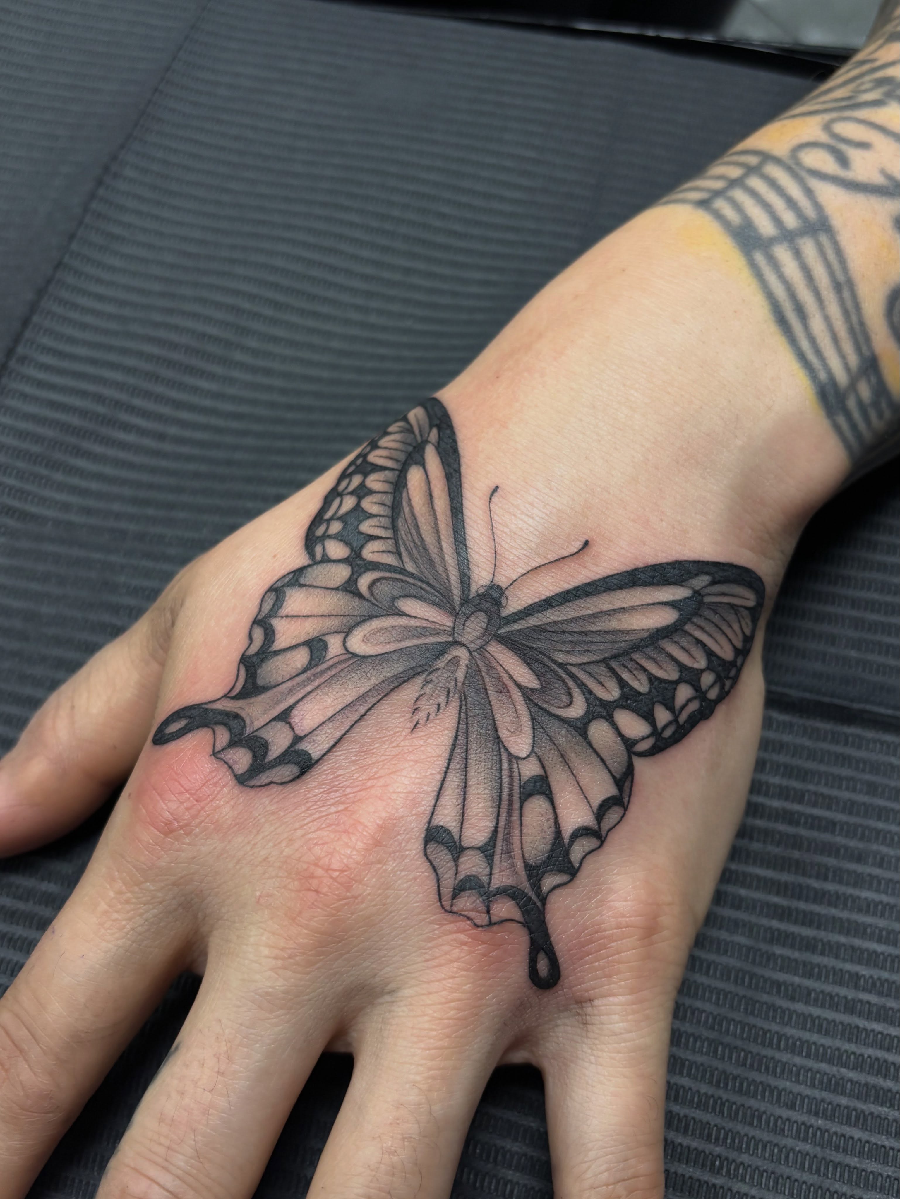 Butterfly black and grey tattoo on the hand by Jennifer Flores