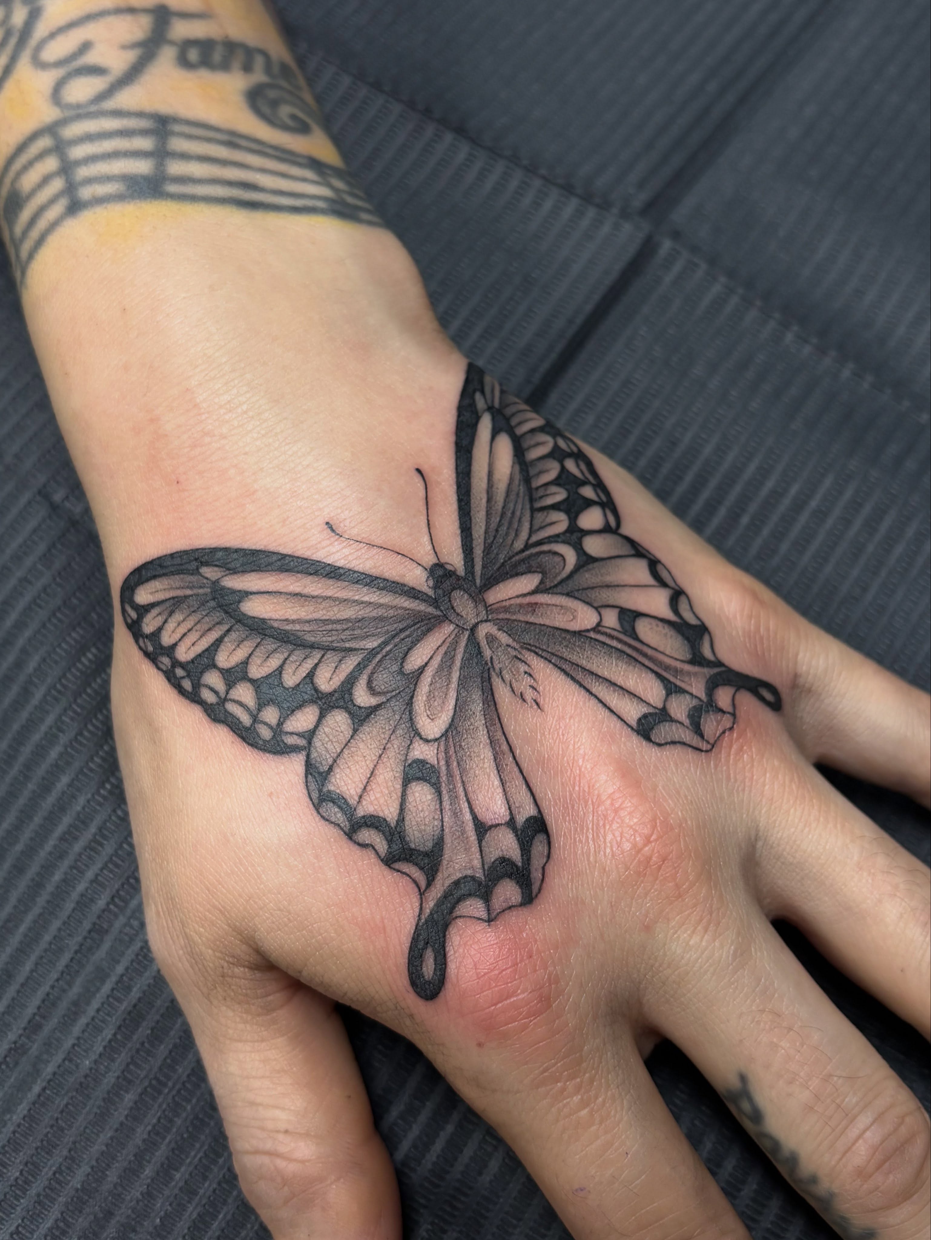 Butterfly black and grey tattoo on the hand by Jennifer Flores