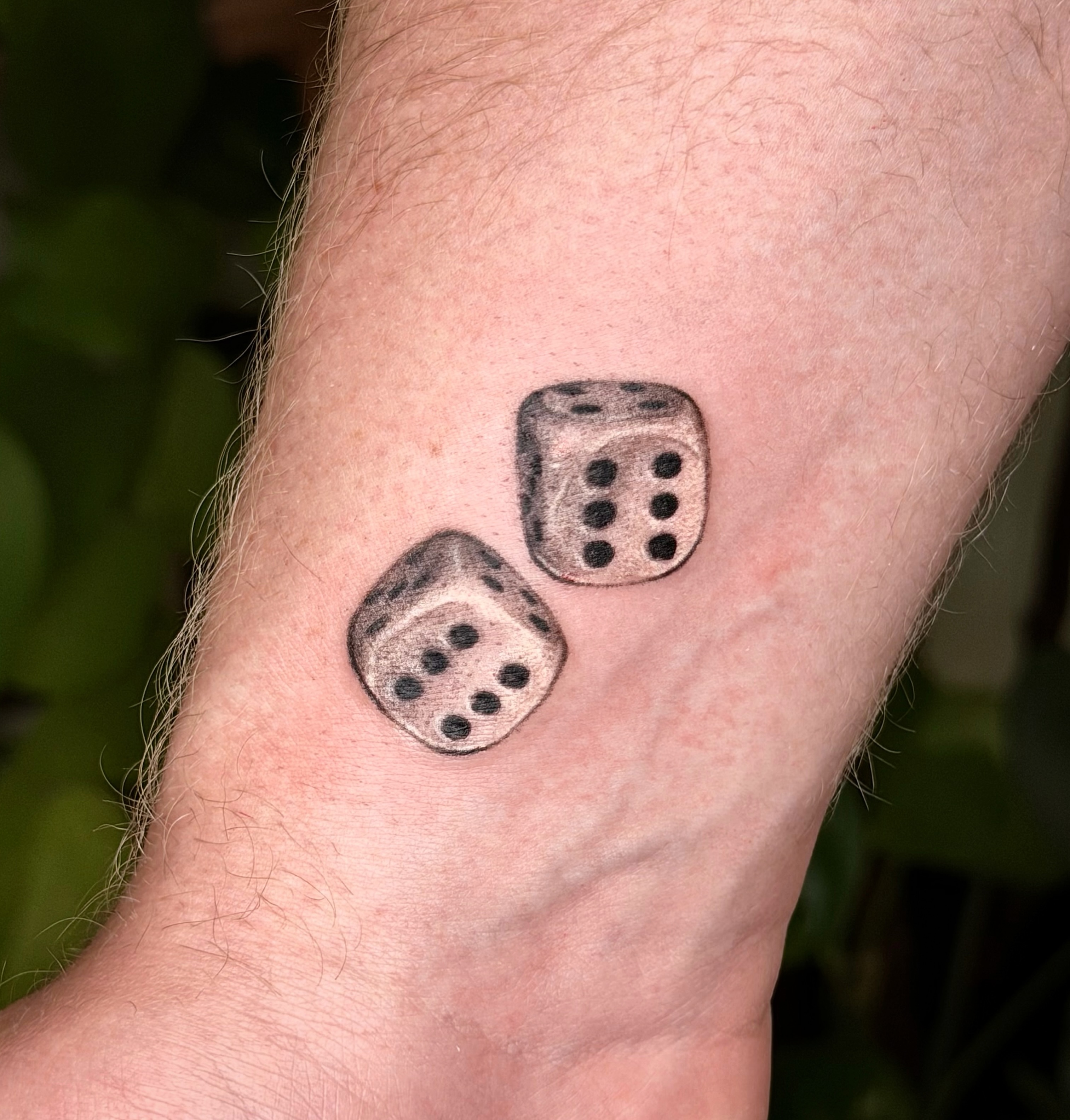 Dice black and grey tattoo on the forearm by Xin Huang