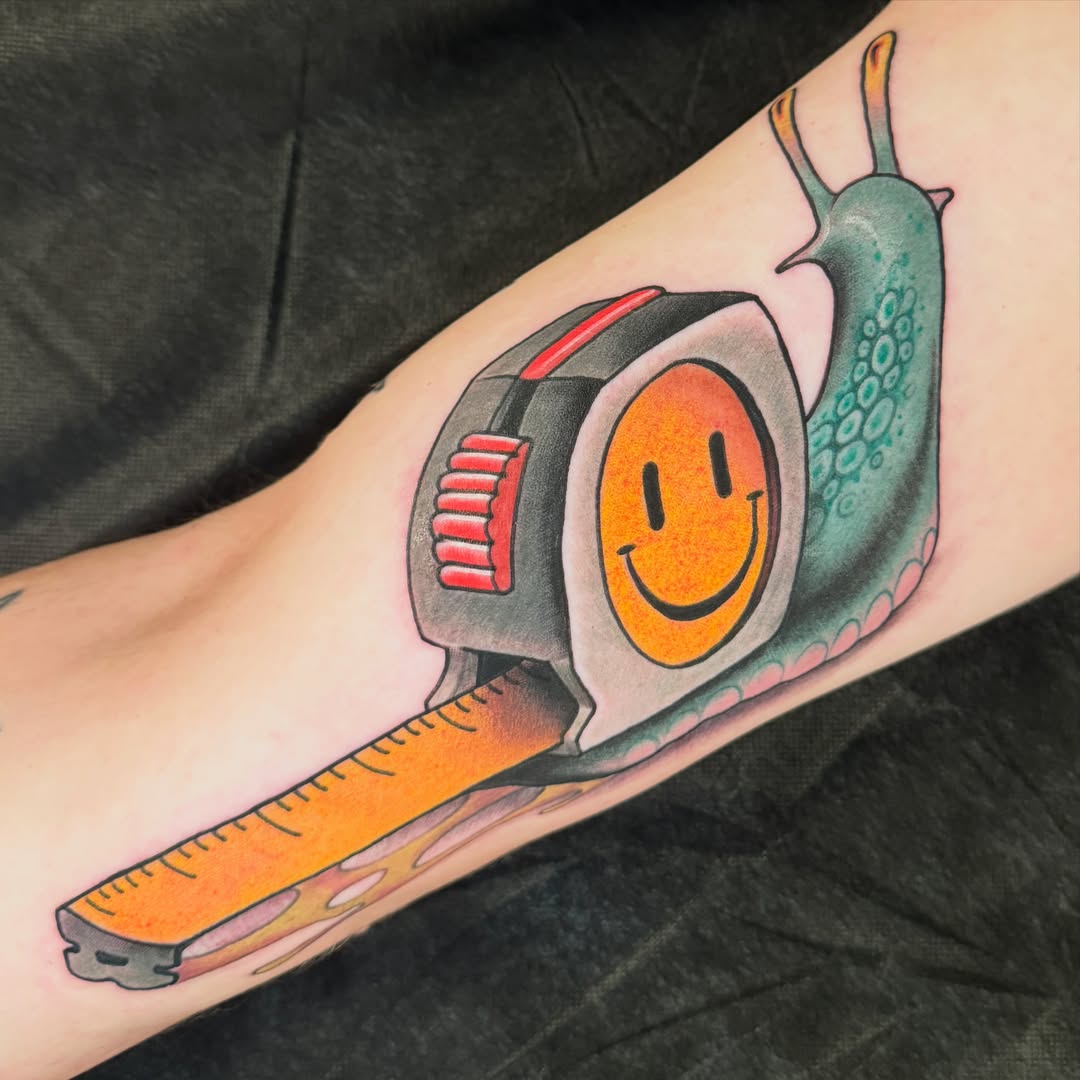 Tape measure with smiley face American traditional tattoo on the forearm by JoshUA Bowers, Des Moines, Iowa