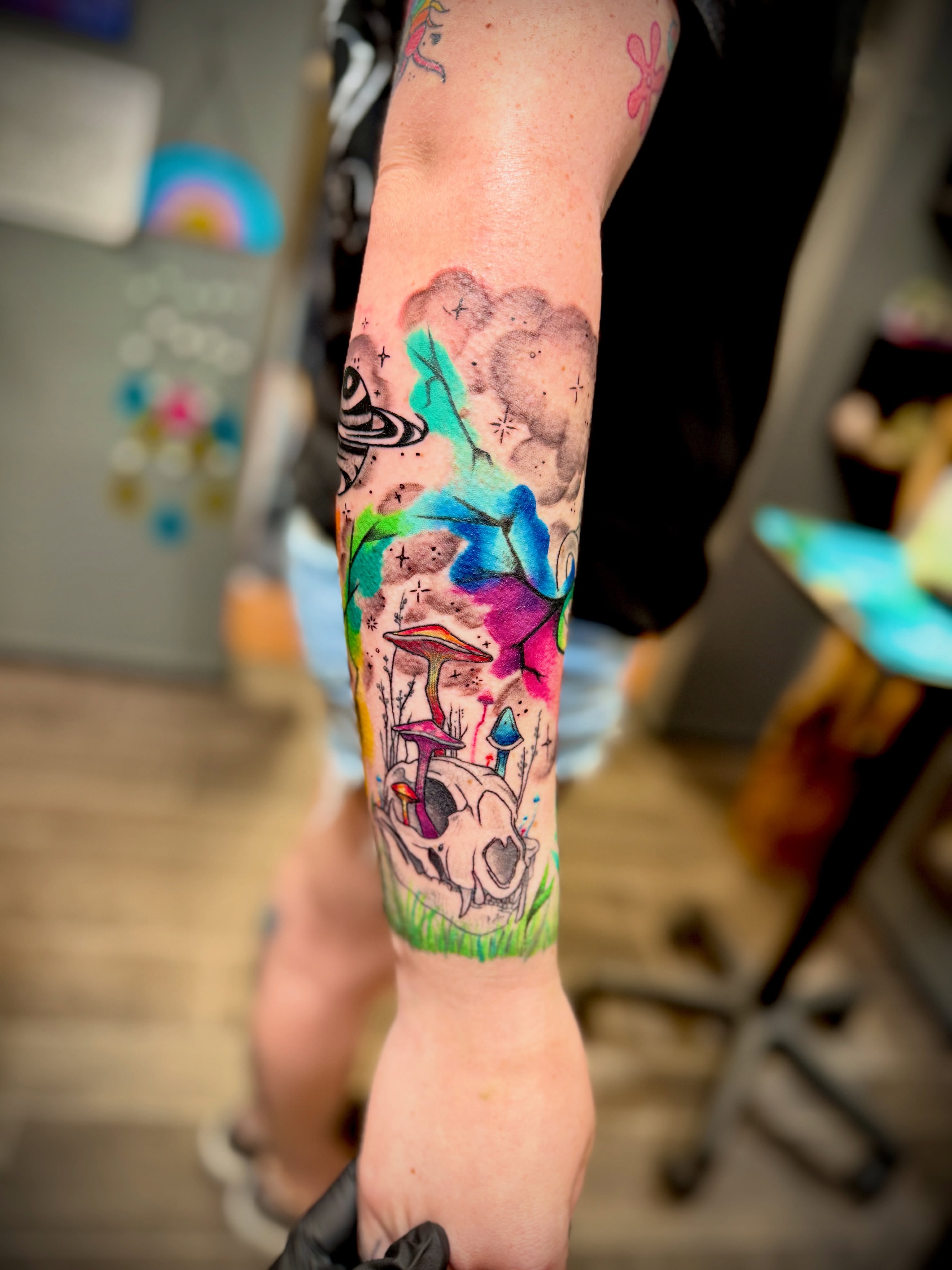 Psychedelic landscape watercolor tattoo on the forearm by Kacy Blalock
