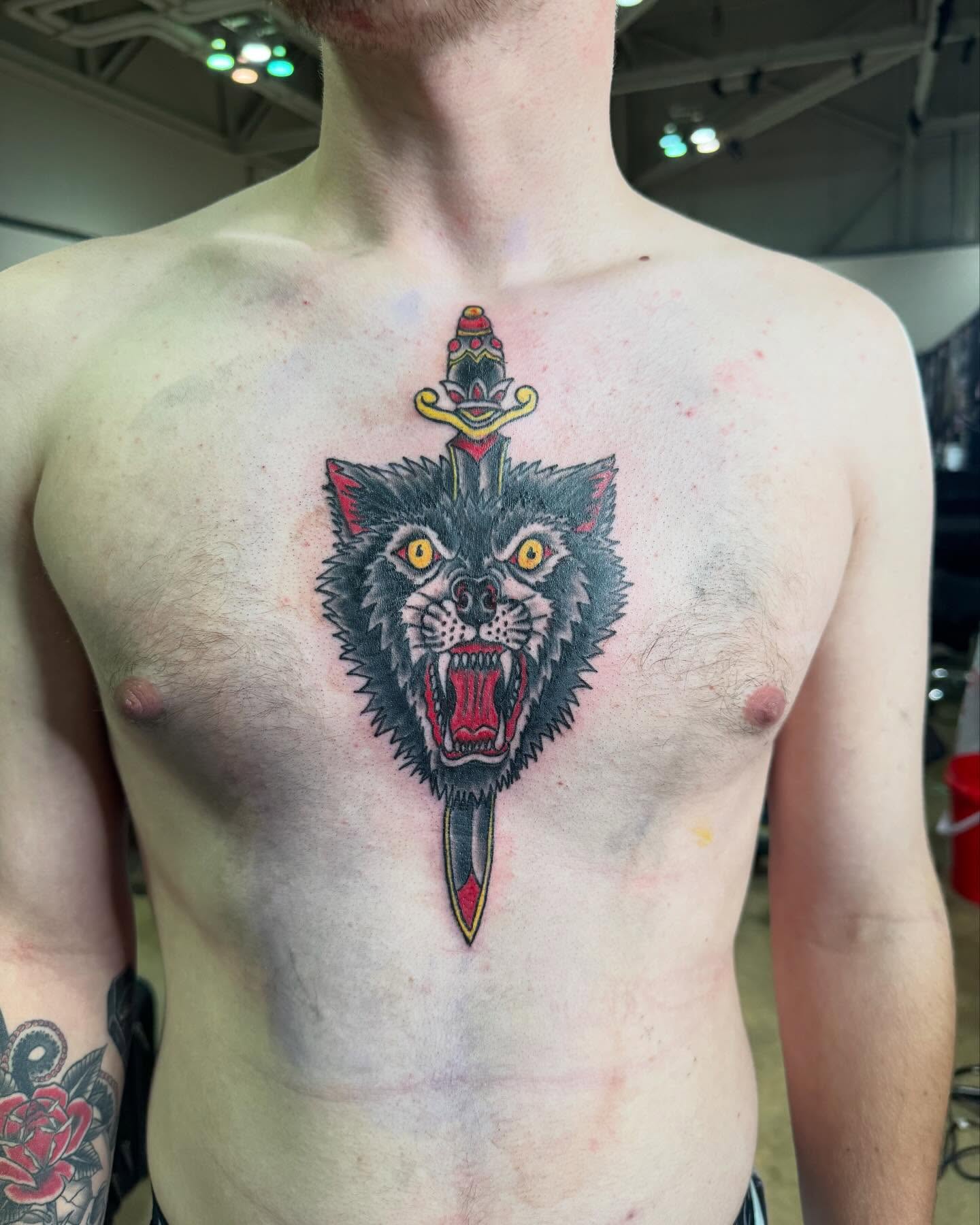 Wolf head with dagger American traditional tattoo on the chest by Brazun Locker Poloschan