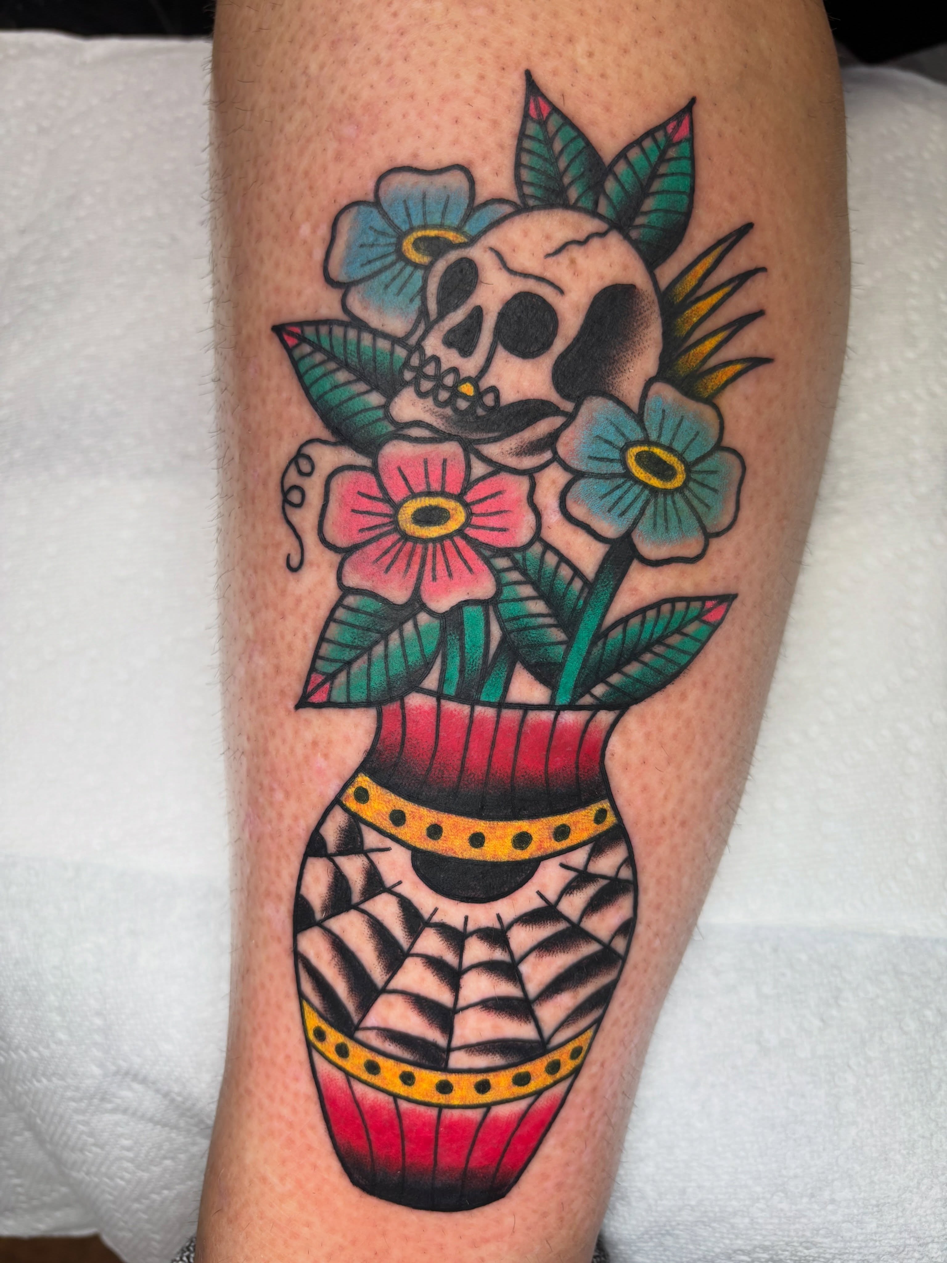 Skull and flowers American traditional tattoo on the forearm by AARON MASTERS - Tattoo Artist