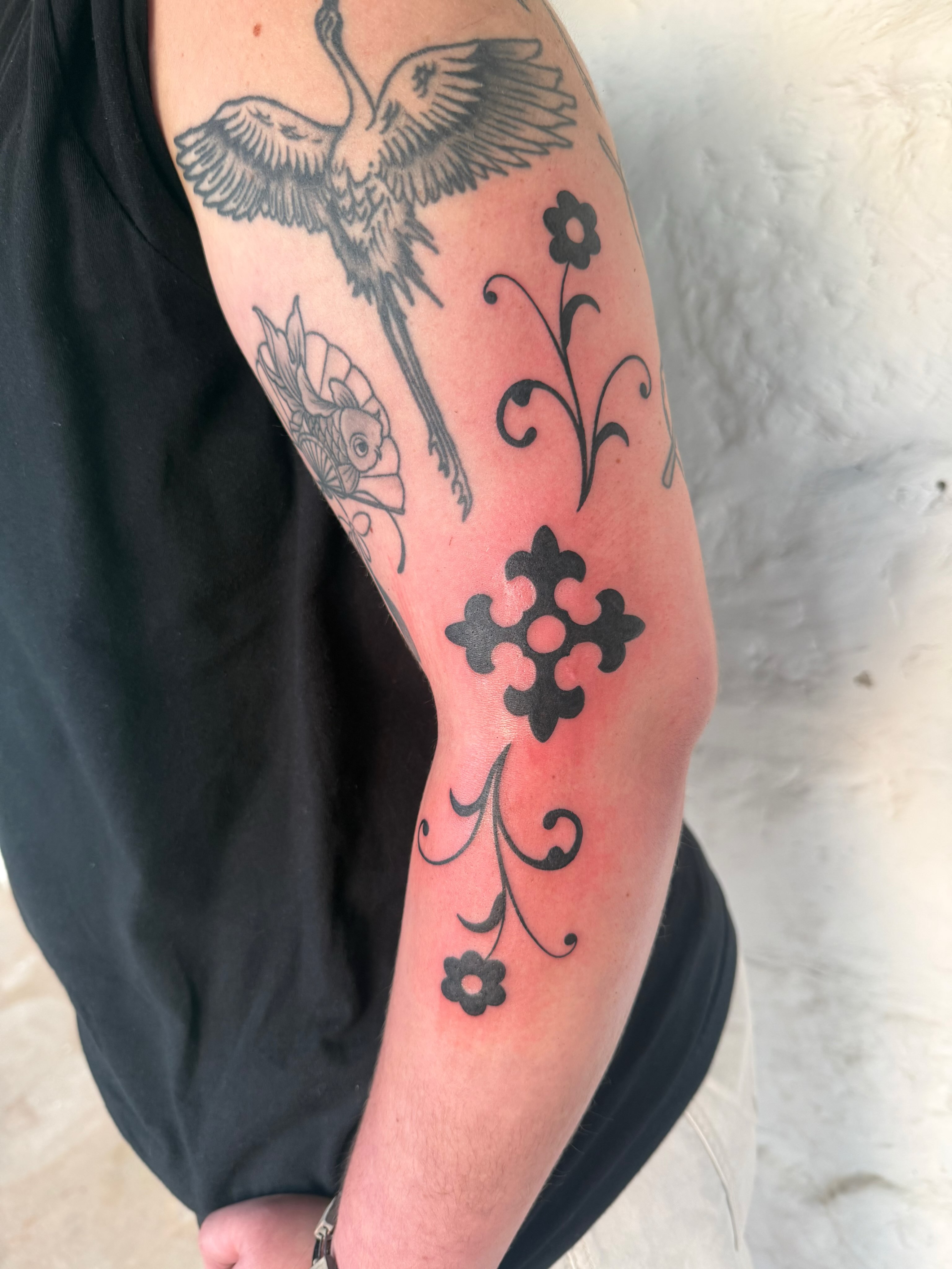 Bird and floral black and grey tattoo on the forearm by sarah