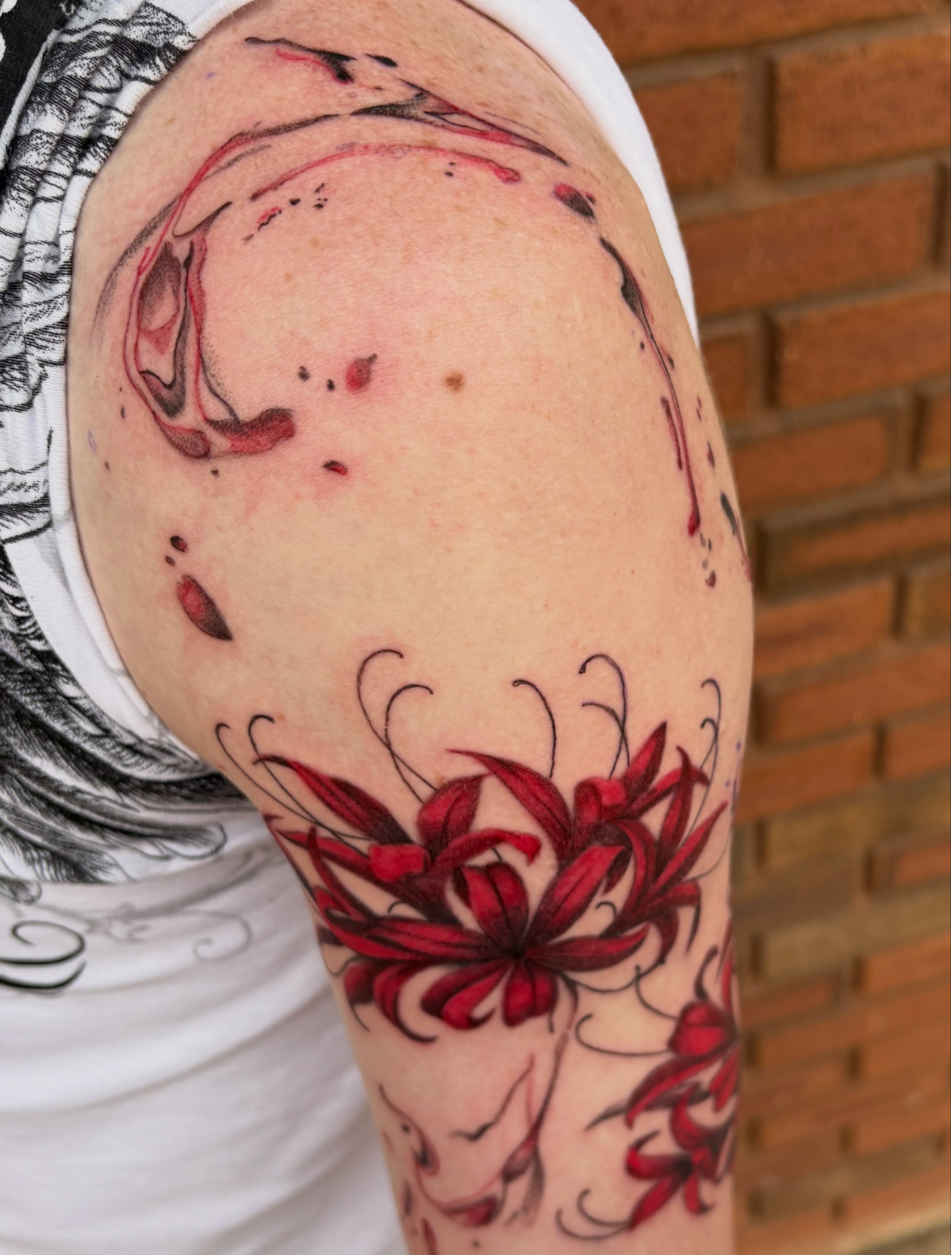 Red flowers new school tattoo on the shoulder by Sierra Maynard