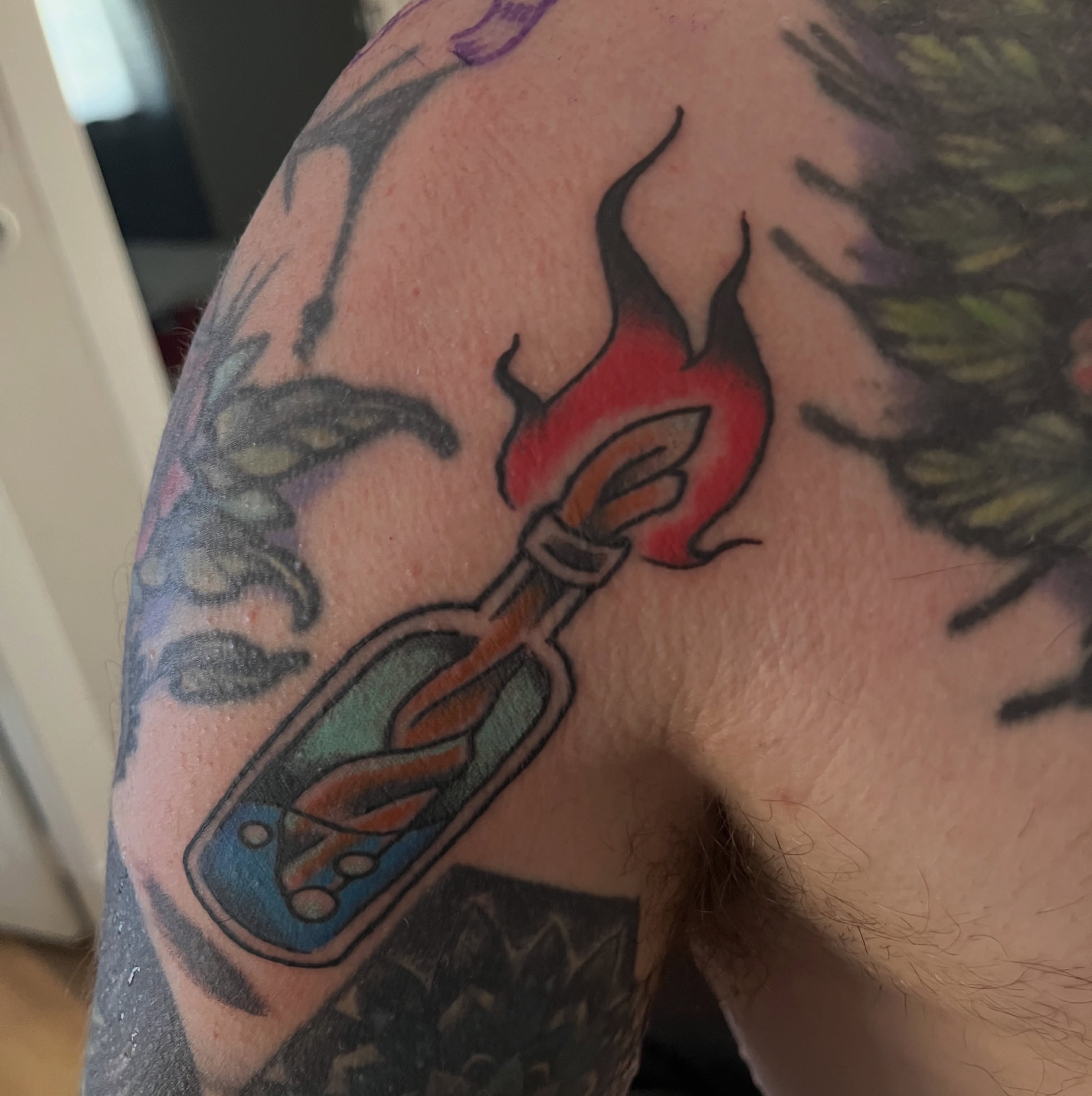 Flame bottle American traditional tattoo on the shoulder by Lacey B, Portland, Oregon