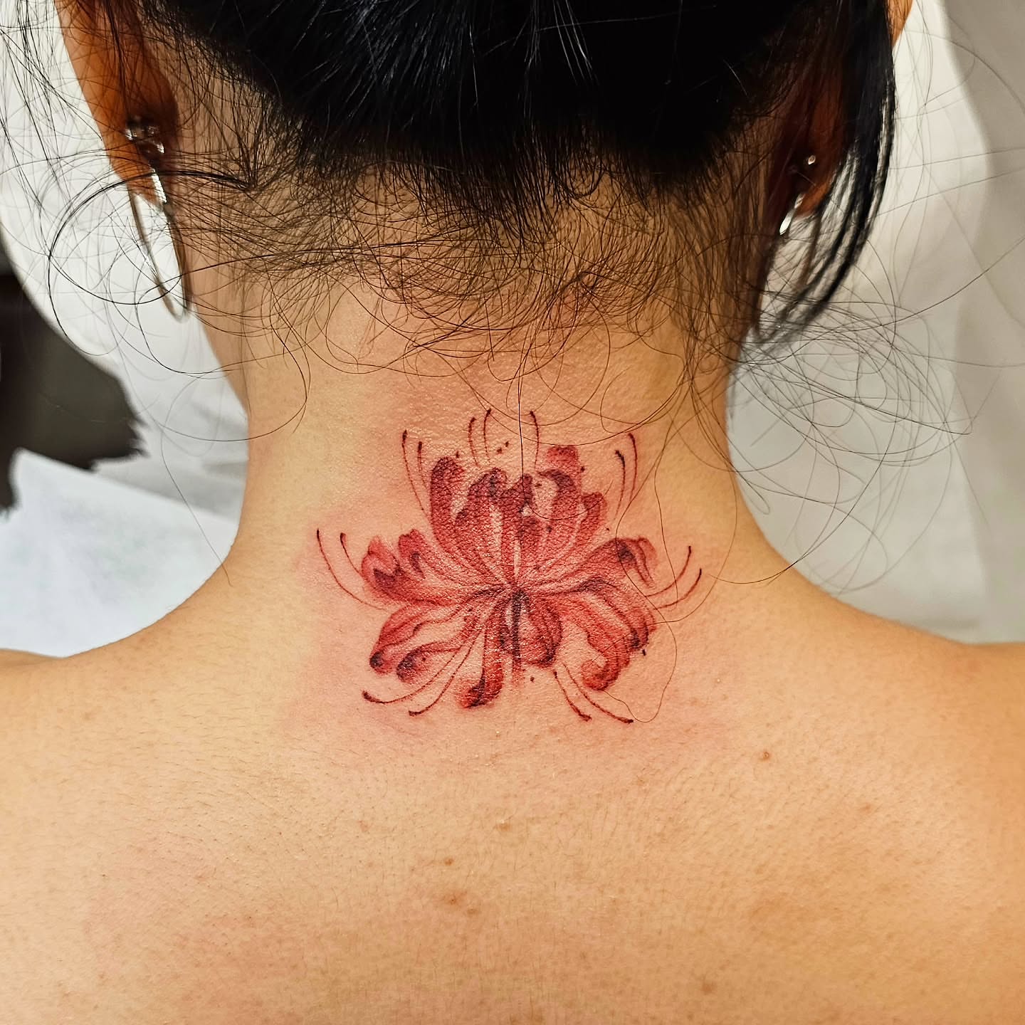 Flower realism tattoo on the neck by Lili Gu