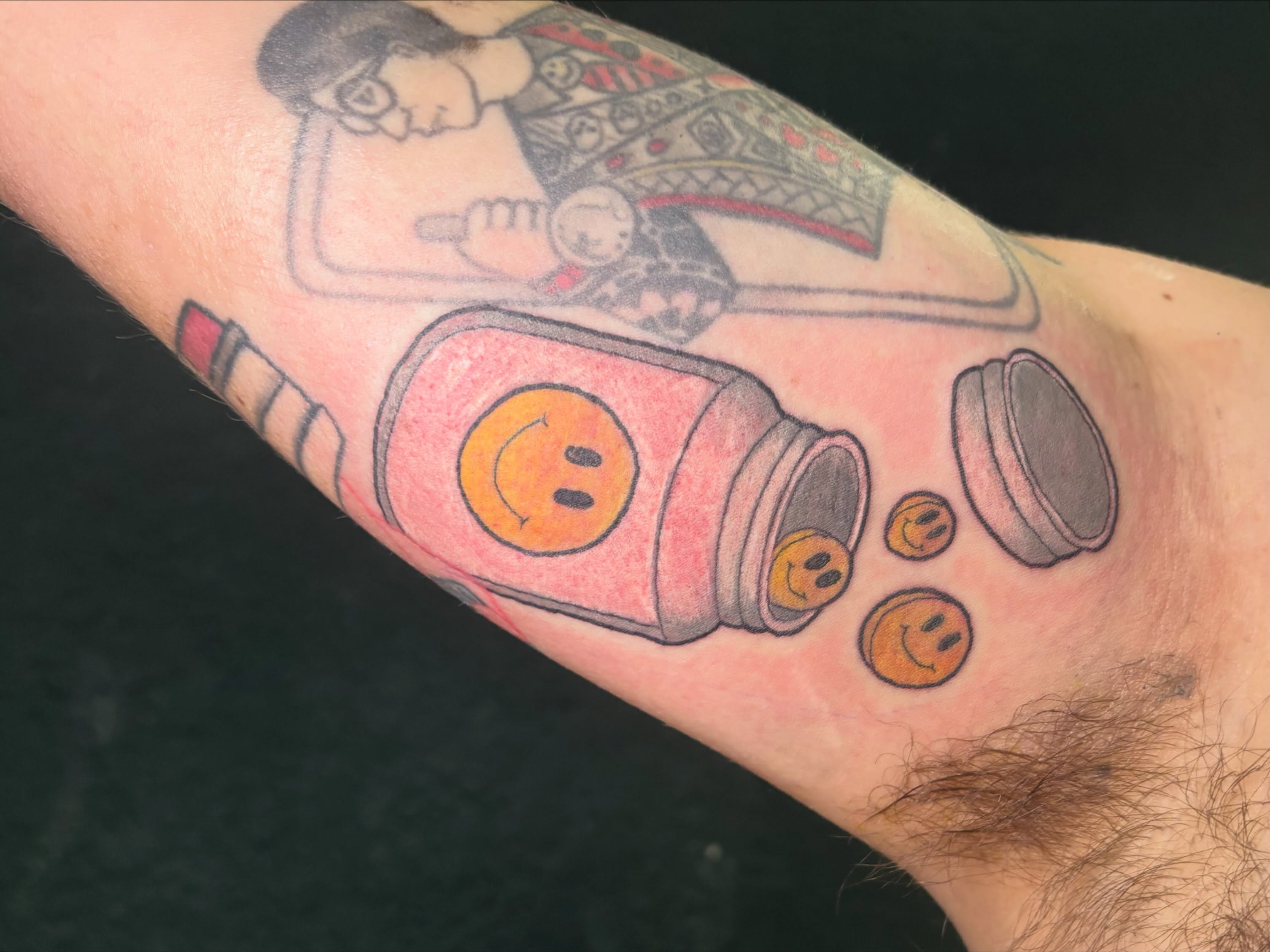 Pill bottle with smiley faces dotwork tattoo on the forearm by Emma ๐