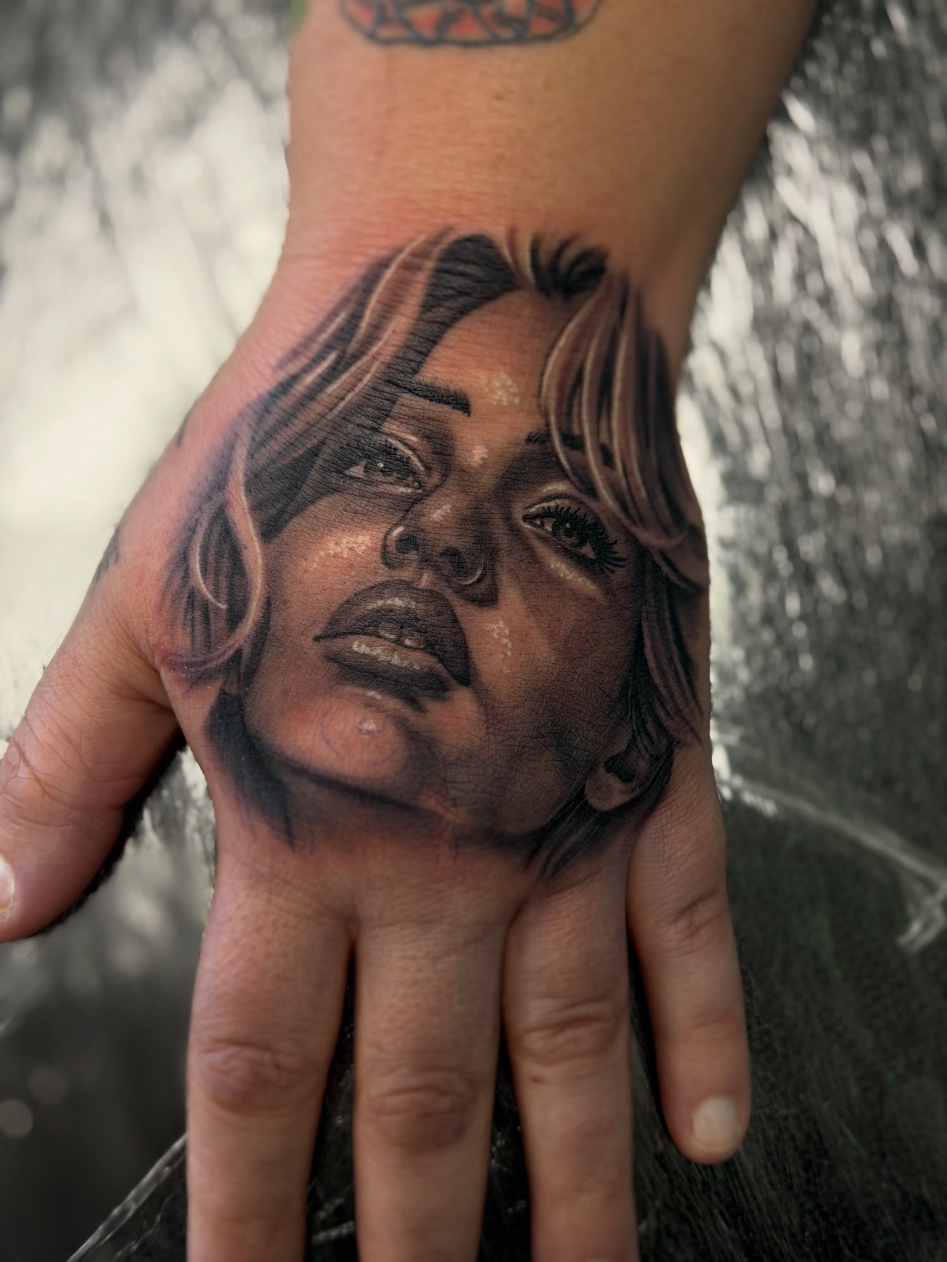 Portrait realism tattoo on the hand by Cameron Mills - Tattoo artist