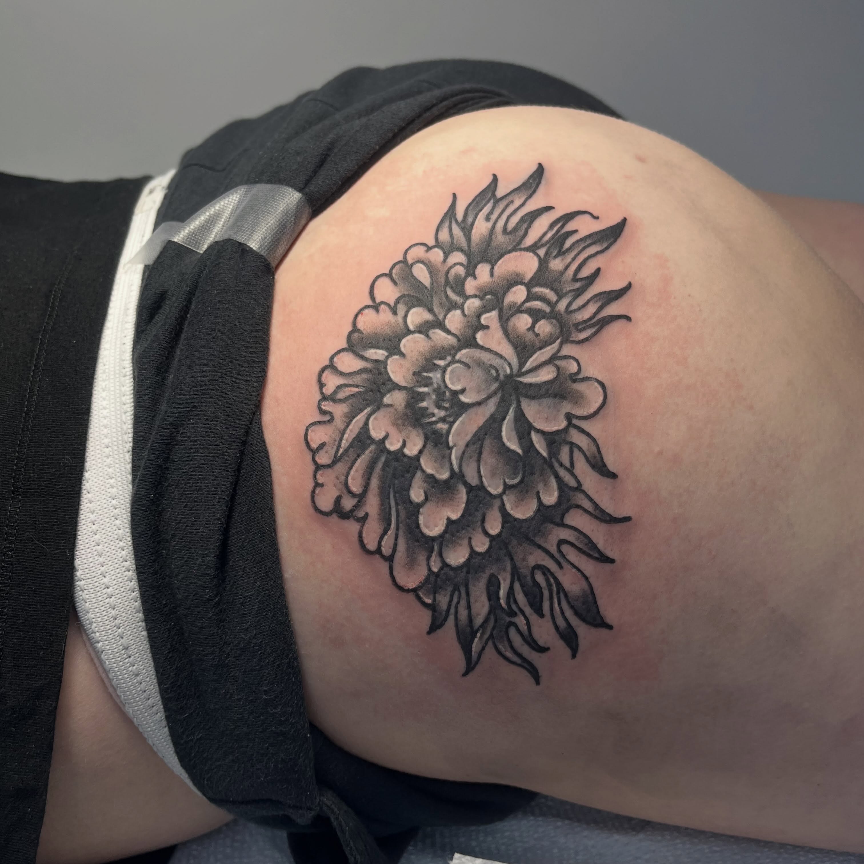 Peony black and grey tattoo on the thigh by Sour Tattoo, Somerville, Massachusetts