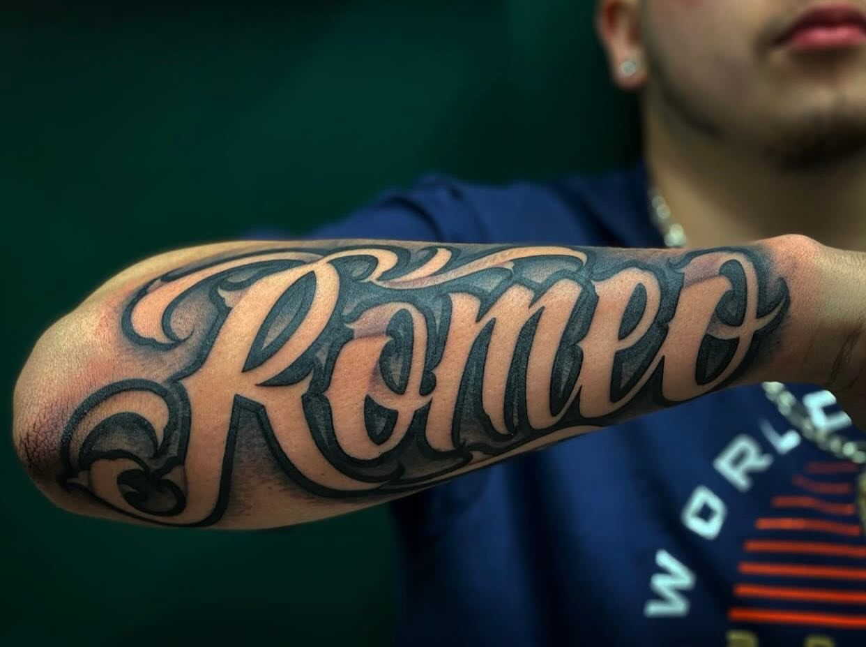 Romeo lettering script tattoo on the forearm by Lex Miranda