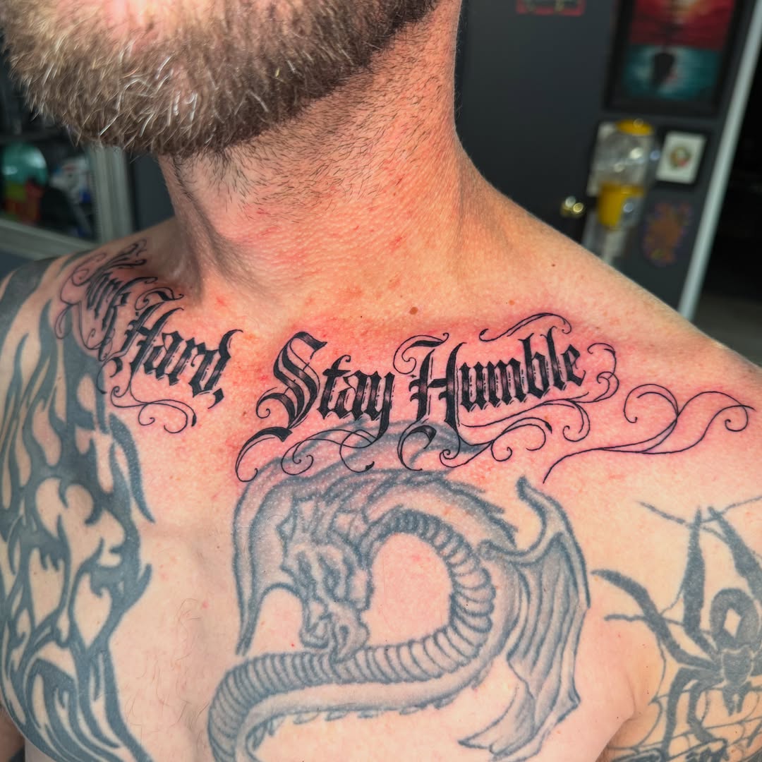 Stay Humble lettering script tattoo on the chest by Beau Zeis
