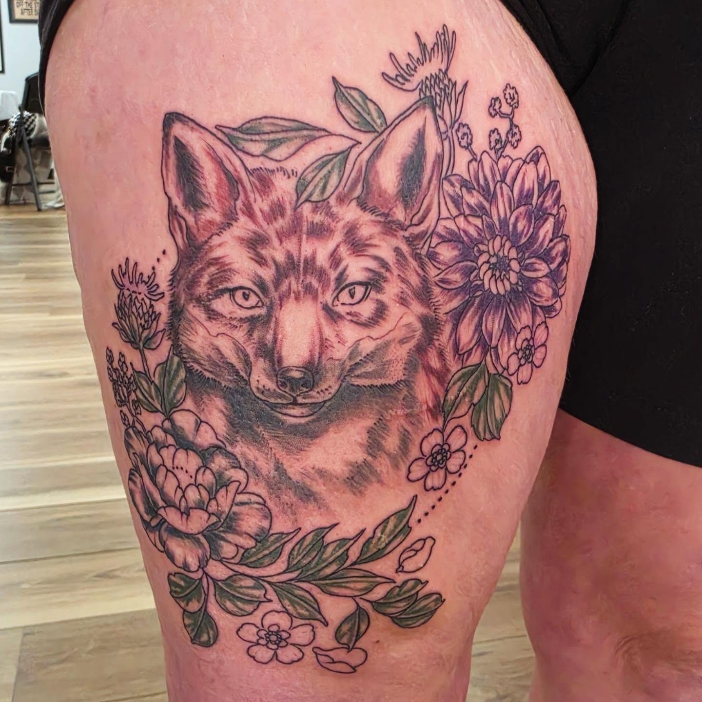 Wolf and flowers realism tattoo on the thigh by Colleen