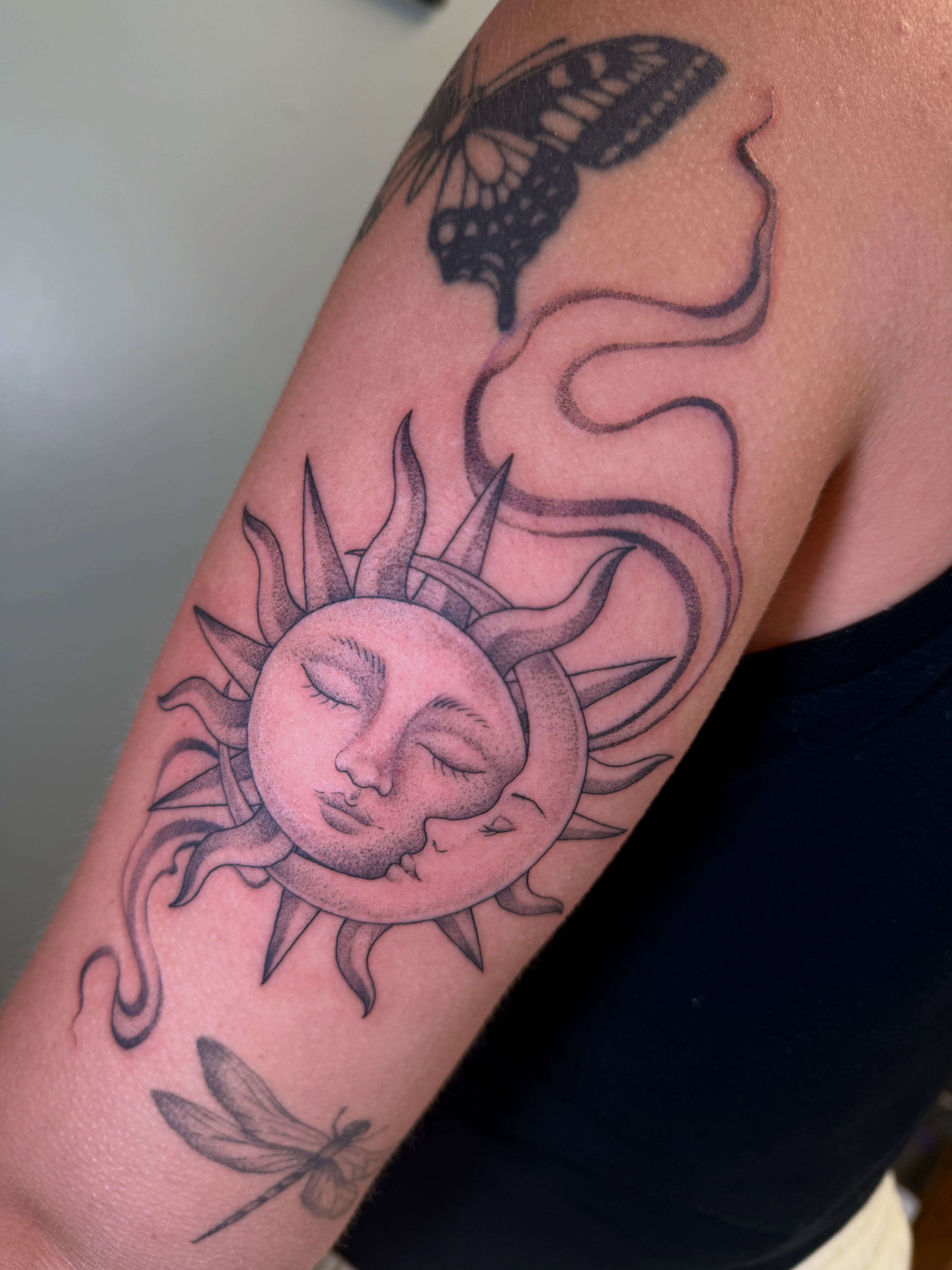 Sun and moon realism tattoo on the upper arm by Koryn Donnelly