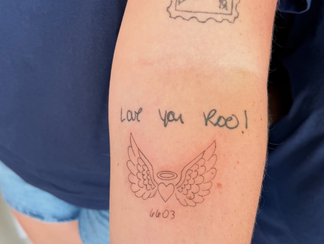 Wings and heart black and grey tattoo on the forearm by Fineline Tattoo