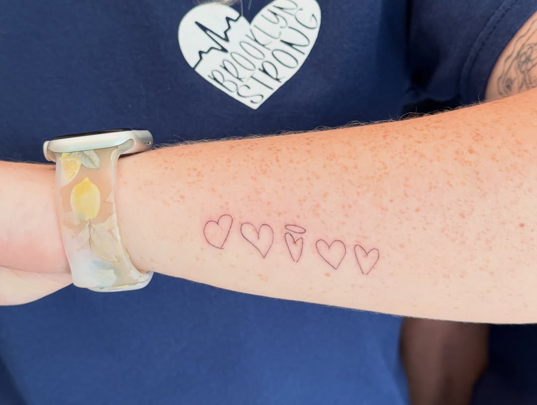 Five hearts minimalist tattoo on the forearm by Fineline Tattoo