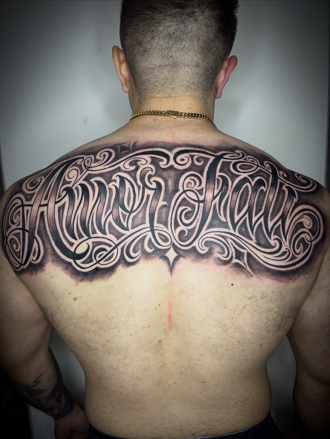 Ornamental script lettering Chicano tattoo on the back by Adrian Ram 🇬🇾🇵🇭