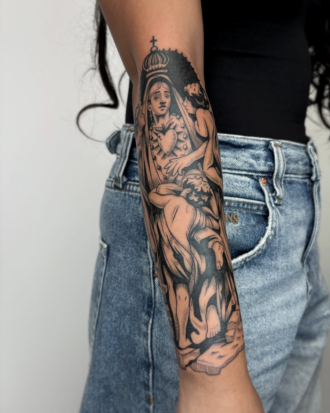 Religious figure black and grey tattoo on the forearm by Kuya, Berkeley, California