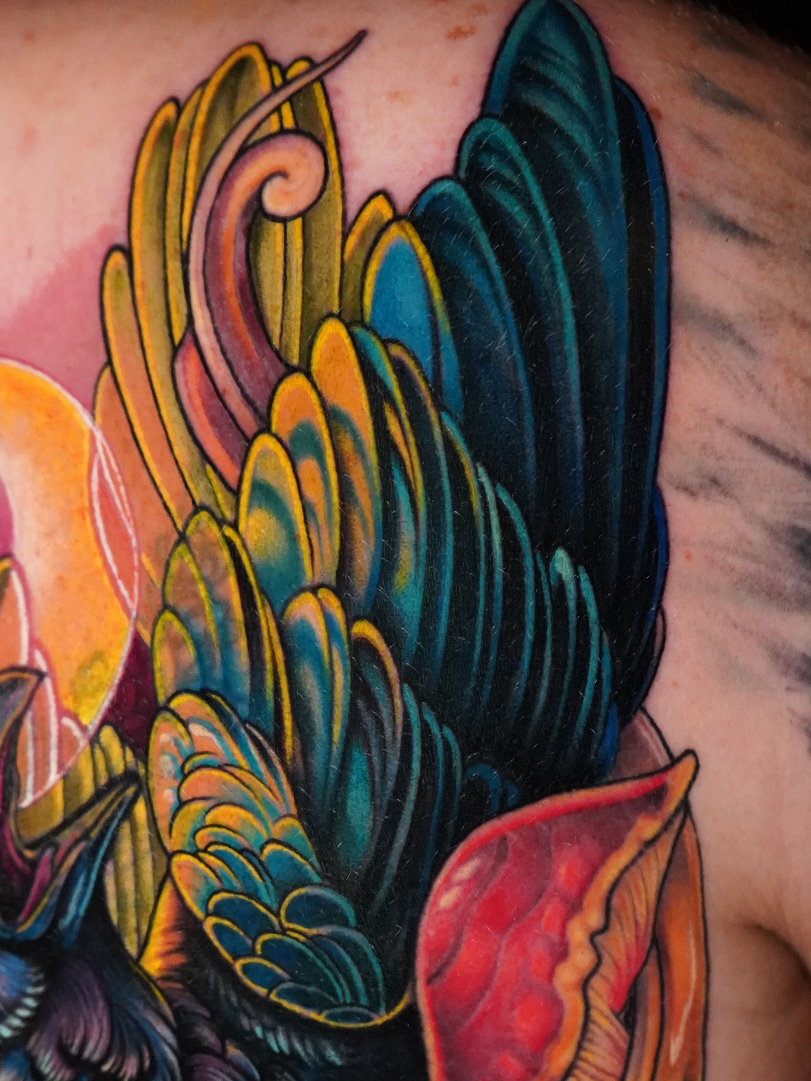 Wing and flower new school tattoo on the back by Haley Corinne