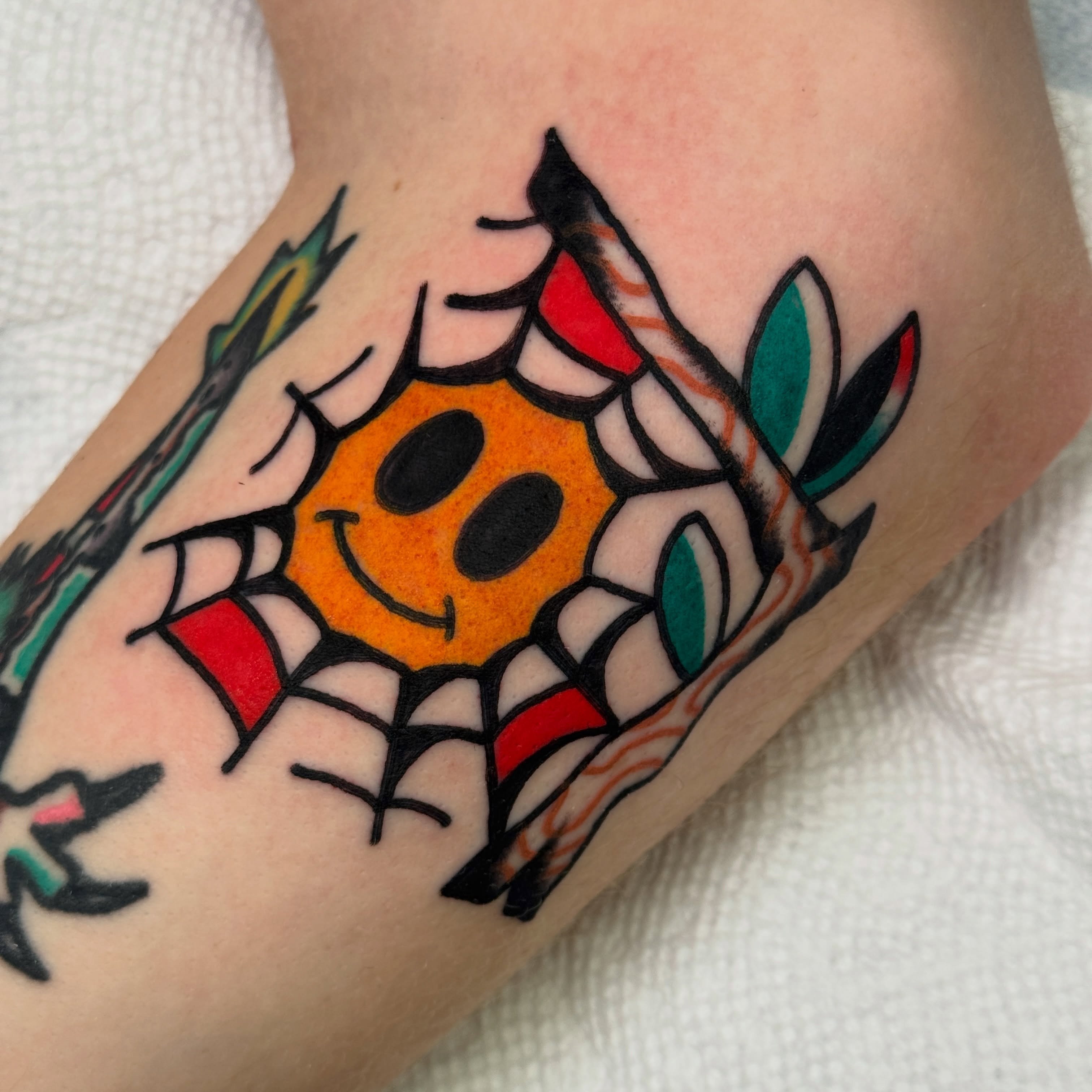 Smiley face American traditional tattoo on the forearm by Rafael Torres, San Francisco, California