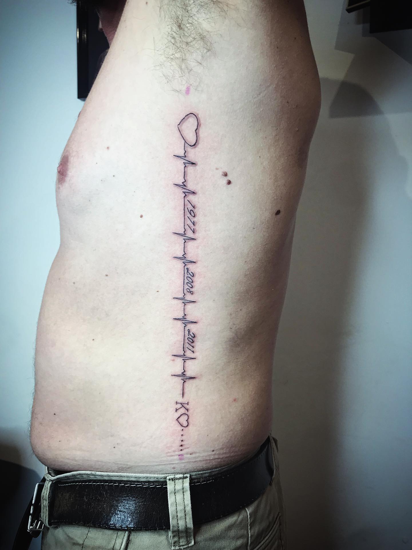 Heart and years fine line tattoo on the ribs by Moss Quito Tattoo