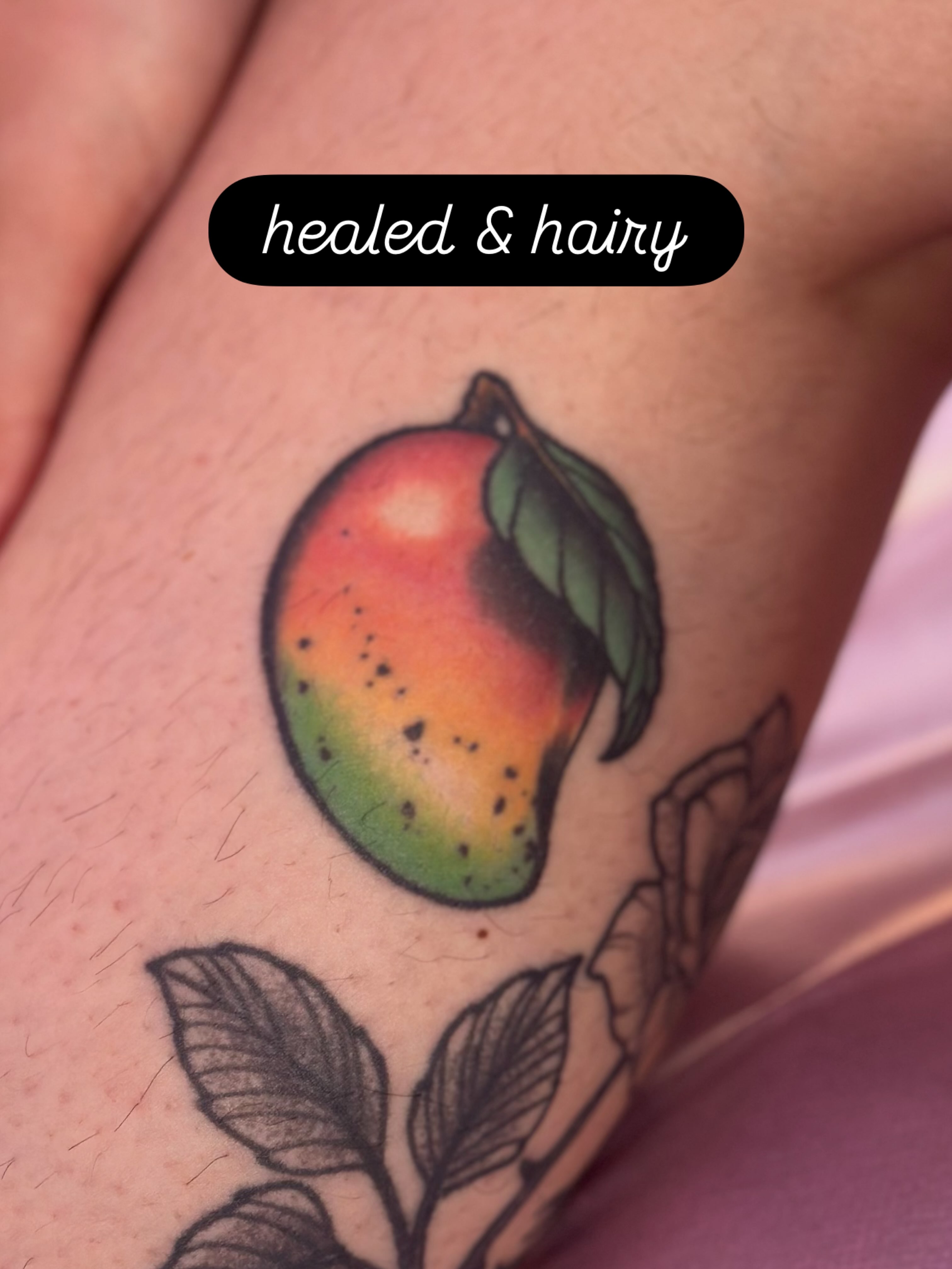 Mango realism tattoo on the forearm by Erin Miller